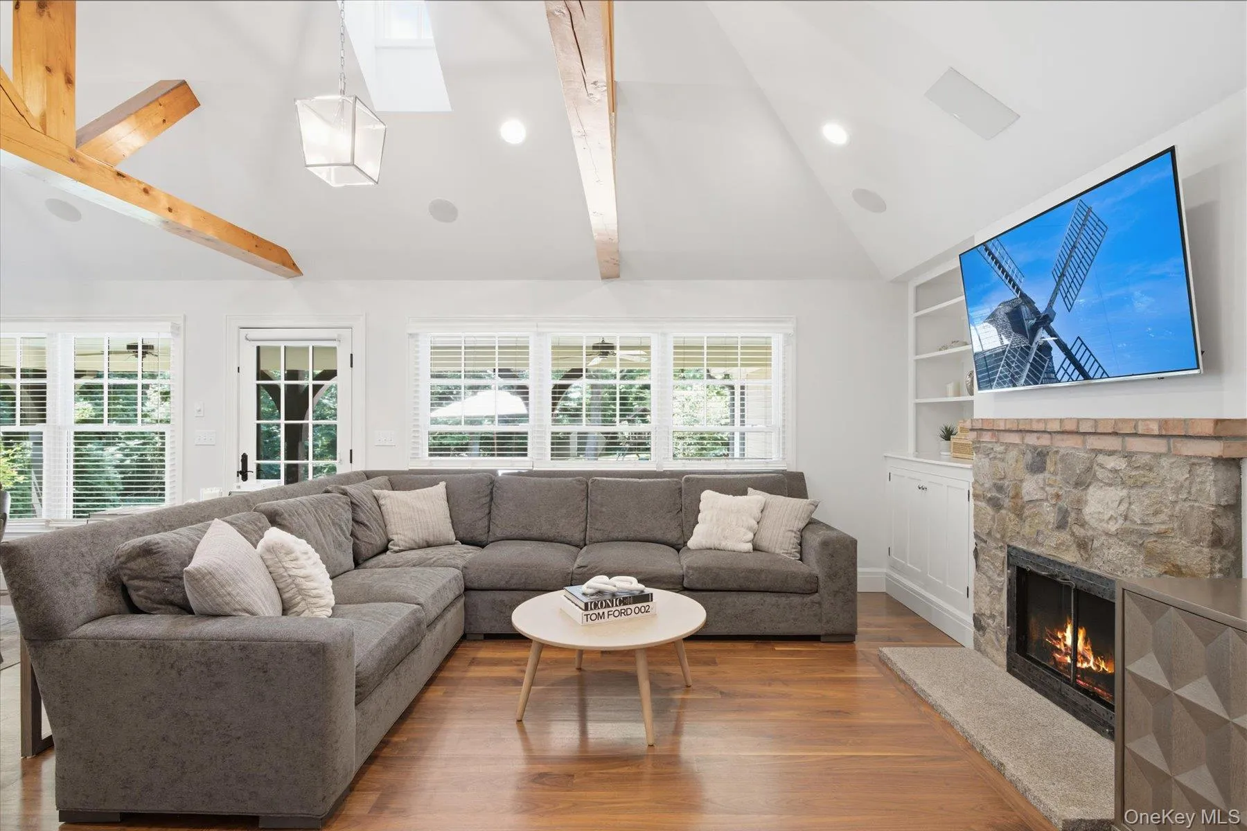 Light filled living space featuring custom beams and a wood-burning fireplace. Light filled living space featuring custom beams and a wood-burning fireplace.