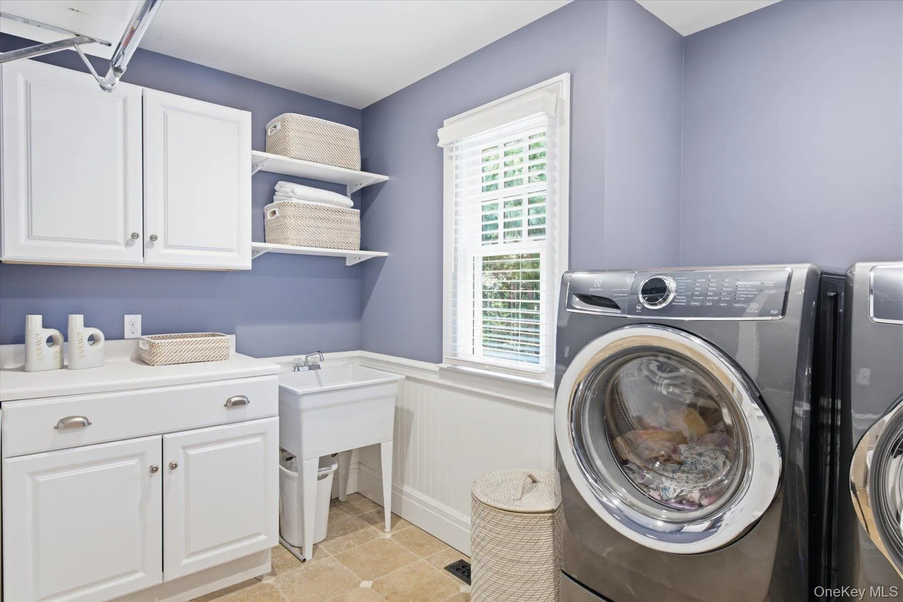Well-designed laundry room with custom cabinetry and utility sink. Well-designed laundry room with custom cabinetry and utility sink.