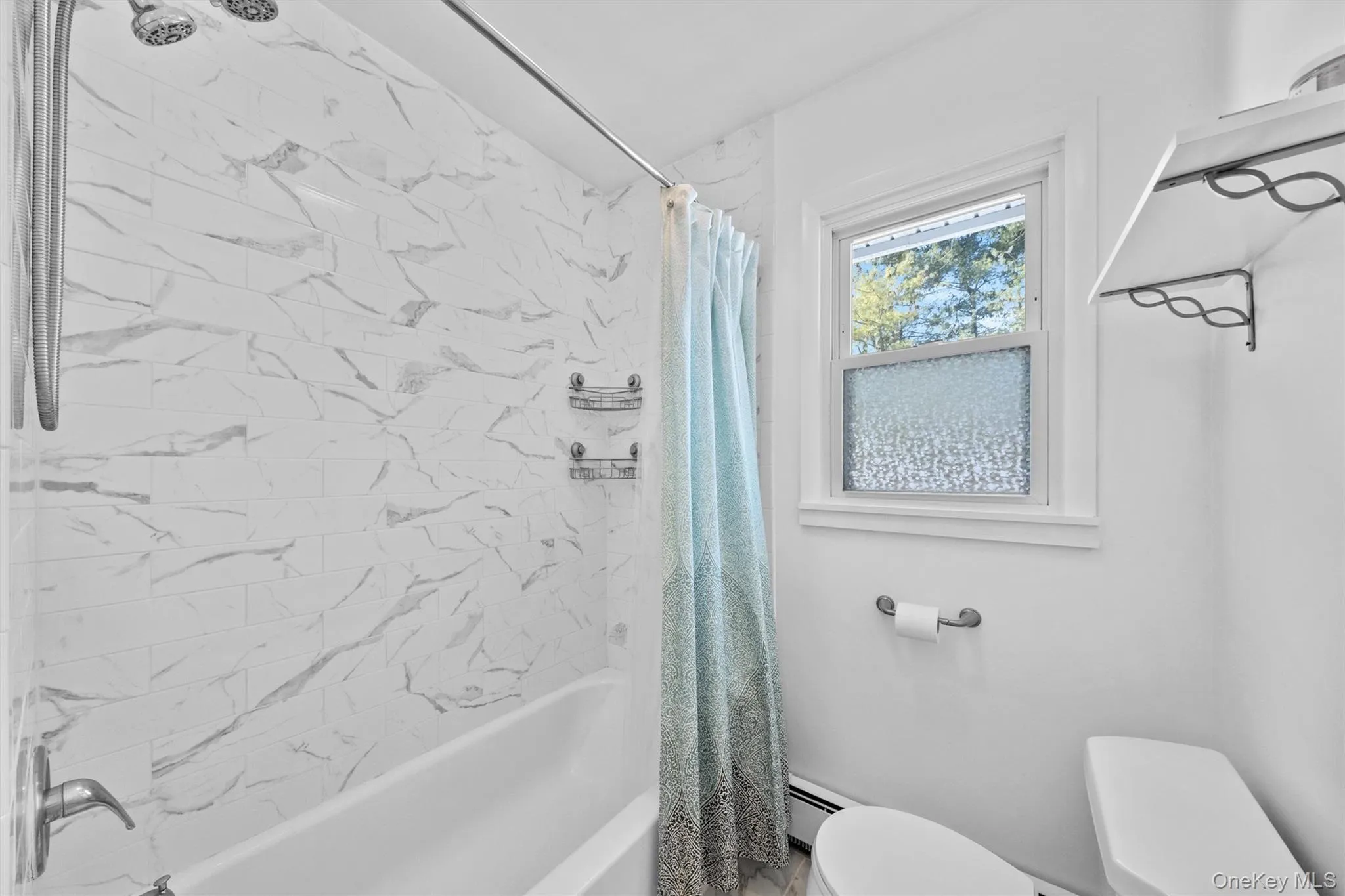 Bathroom with toilet, baseboard heating, and shower / tub combo Bathroom with toilet, baseboard heating, and shower / tub combo