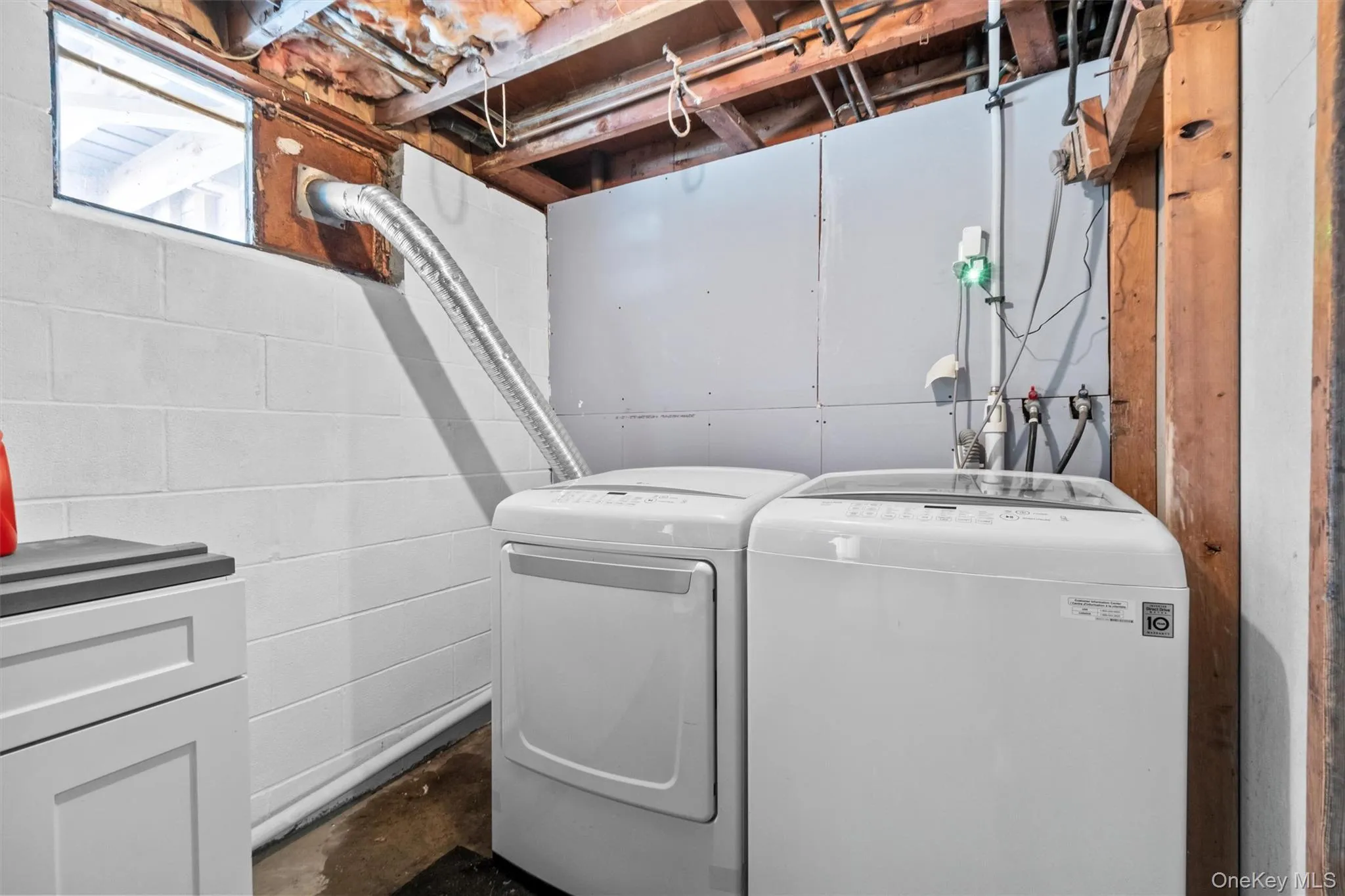 Laundry area with concrete block wall, laundry area, and washer and clothes dryer Laundry area with concrete block wall, laundry area, and washer and clothes dryer