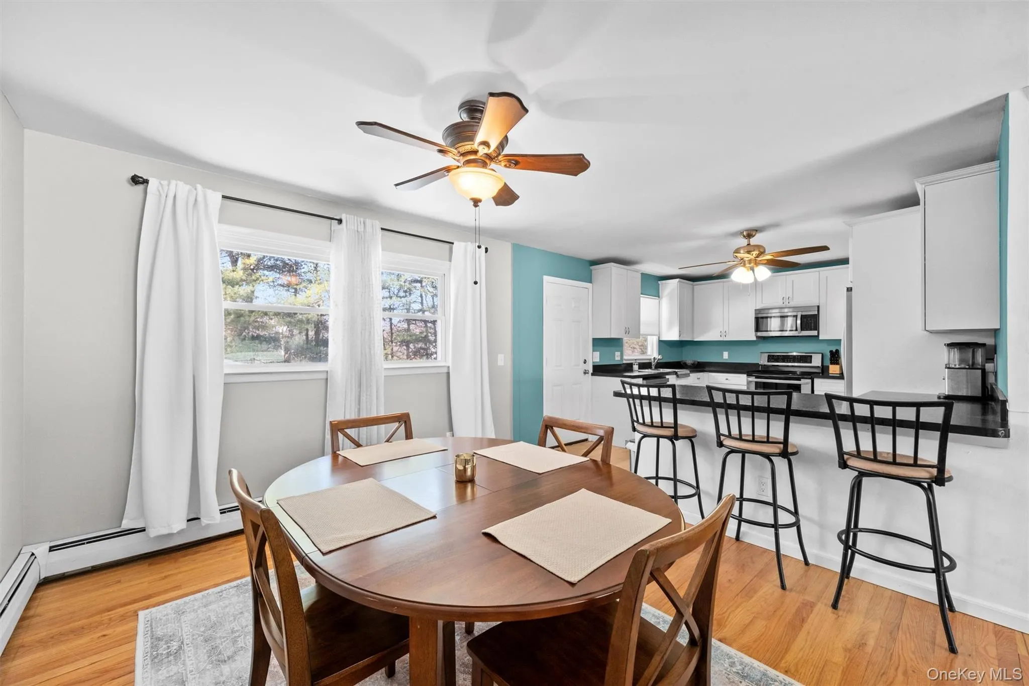 Dining room featuring light wood-style flooring and ceiling fan Dining room featuring light wood-style flooring and ceiling fan