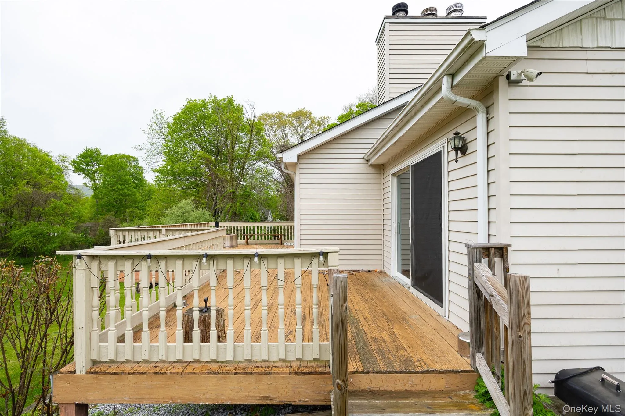 Expansive wood-finish deck with white spindle railing Expansive wood-finish deck with white spindle railing