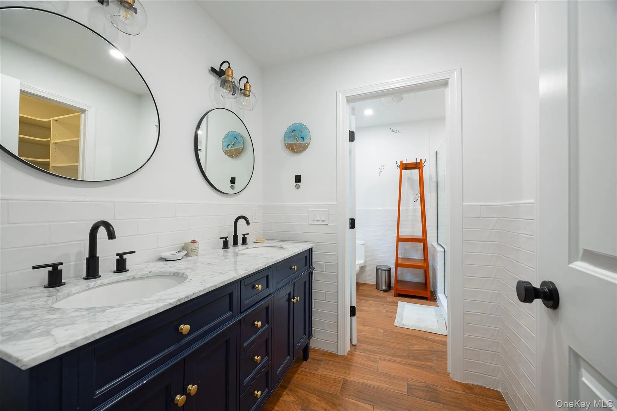 Double vanity featuring a white marble-patterned countertop, dual undermount sinks, and matte black fixtures Double vanity featuring a white marble-patterned countertop, dual undermount sinks, and matte black fixtures