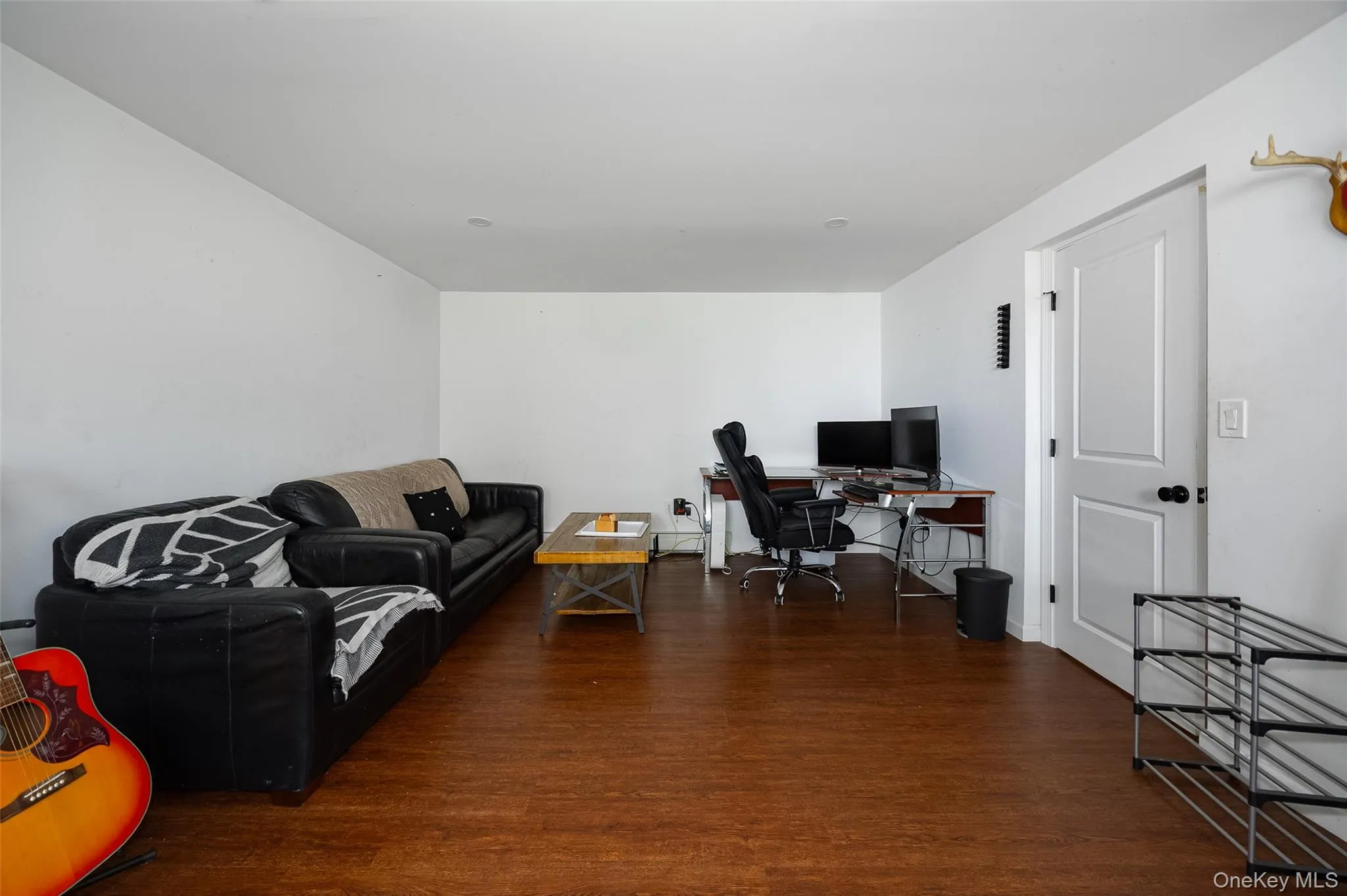 Spacious interior room with wood-finish flooring and crisp white walls Spacious interior room with wood-finish flooring and crisp white walls