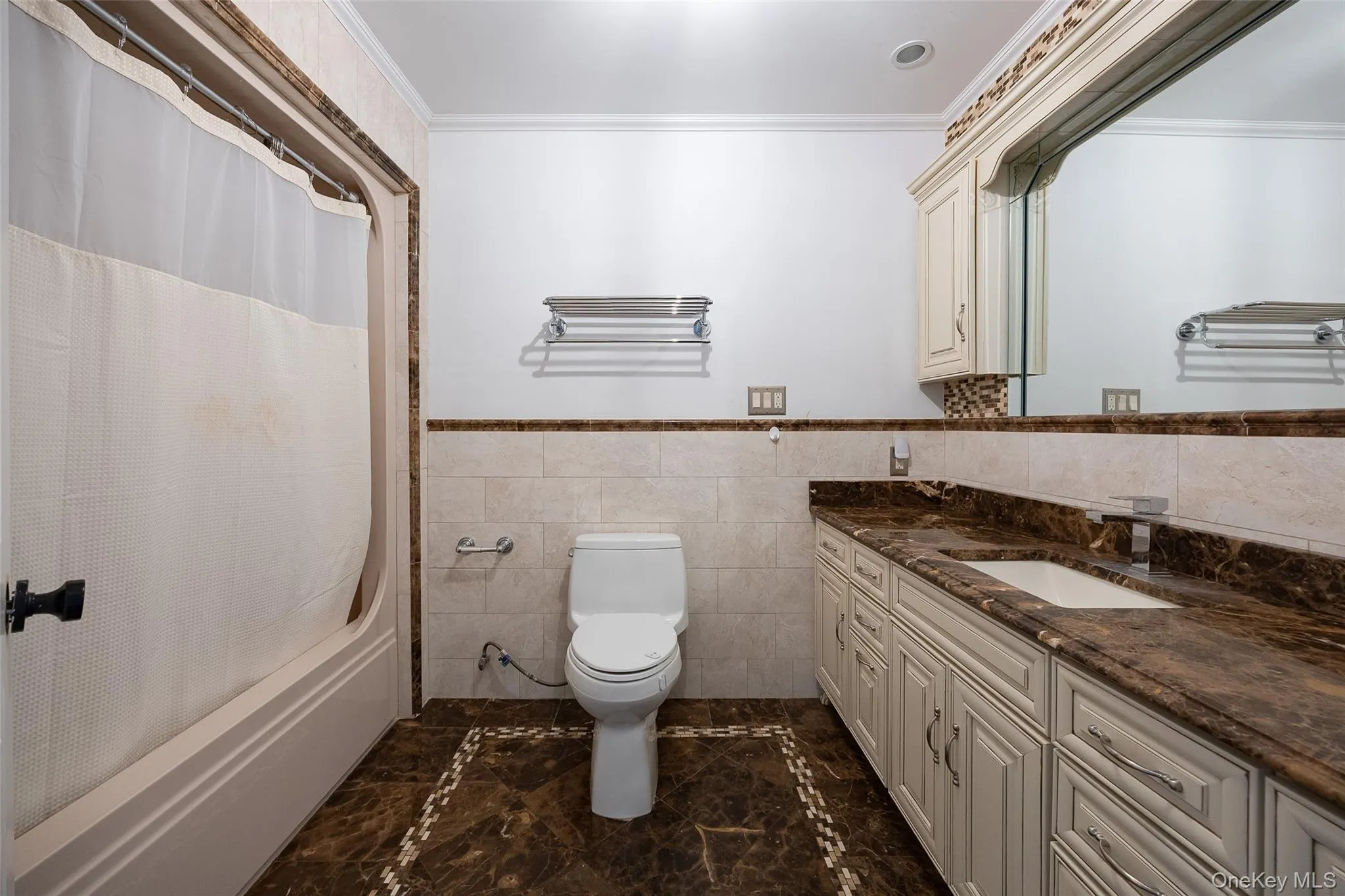 Bathroom featuring a large vanity with a brown stone countertop, integrated rectangular sink, and chrome faucet Bathroom featuring a large vanity with a brown stone countertop, integrated rectangular sink, and chrome faucet
