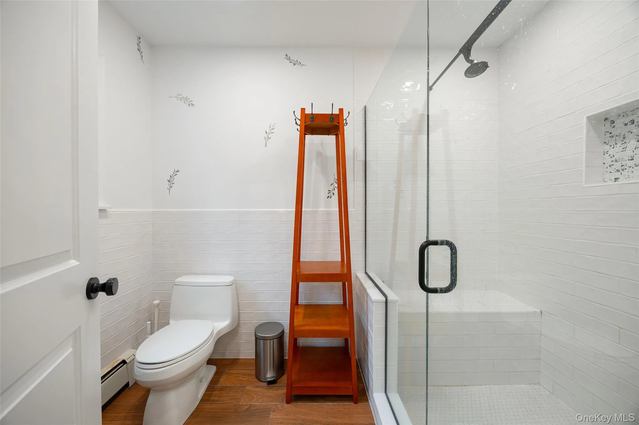 Bathroom with wood-finish flooring and a white toilet Bathroom with wood-finish flooring and a white toilet