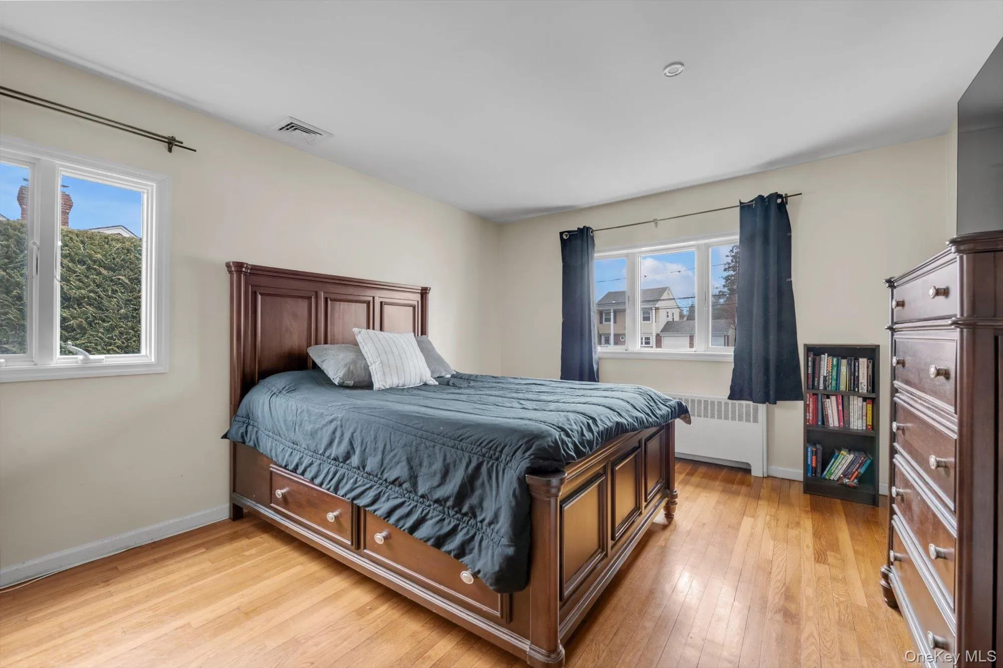 Bedroom featuring light-toned walls and wood-finish flooring Bedroom featuring light-toned walls and wood-finish flooring