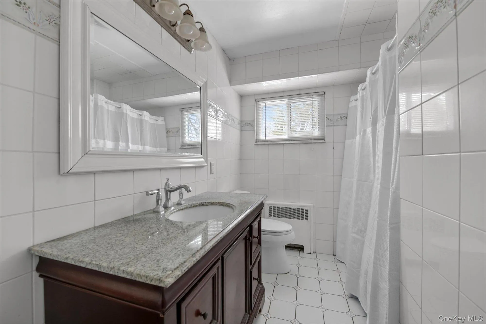 Bathroom featuring a dark wood-finish vanity with a light speckled countertop and undermount sink Bathroom featuring a dark wood-finish vanity with a light speckled countertop and undermount sink