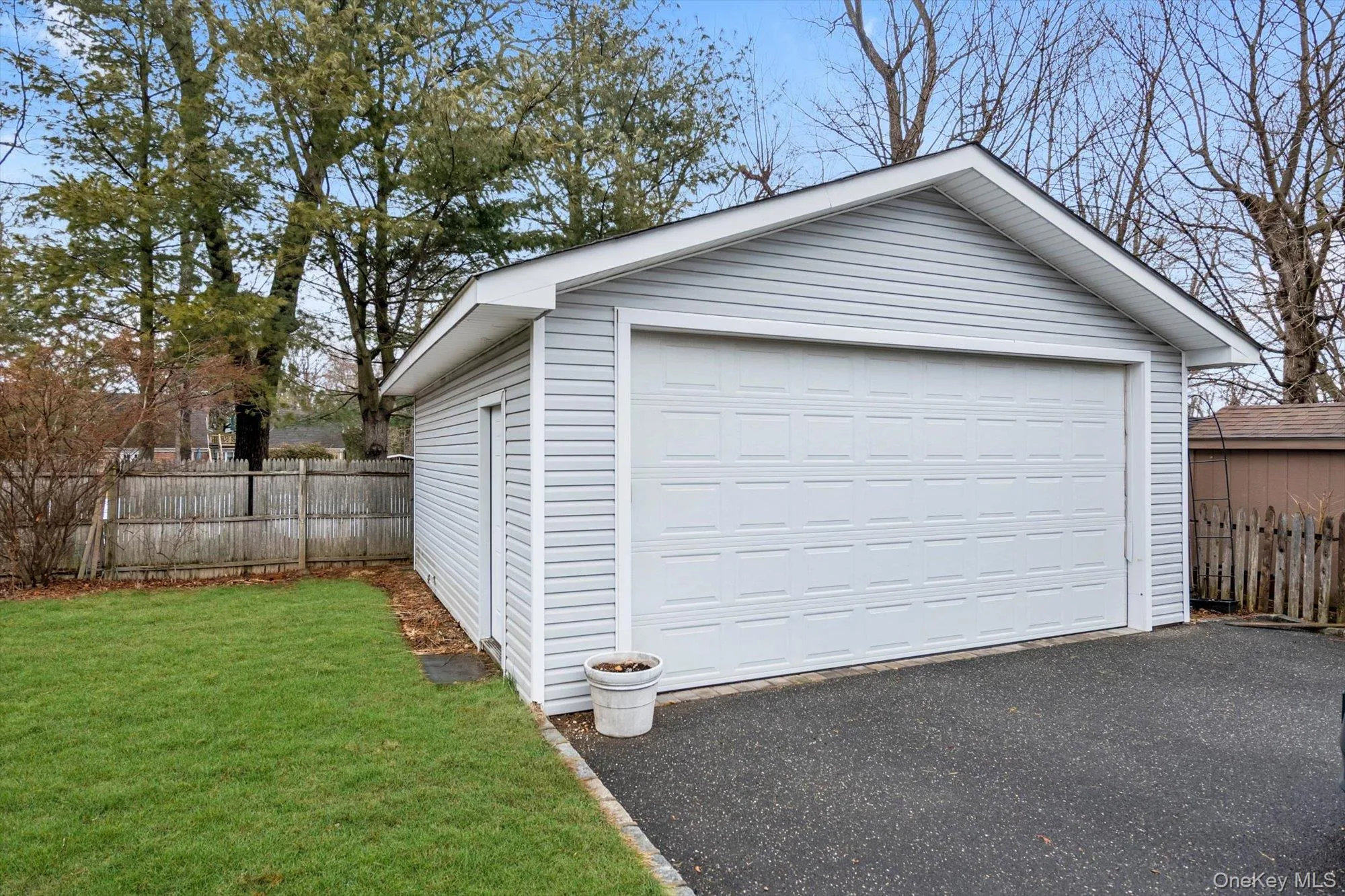 Detached garage with light gray siding and white trim Detached garage with light gray siding and white trim