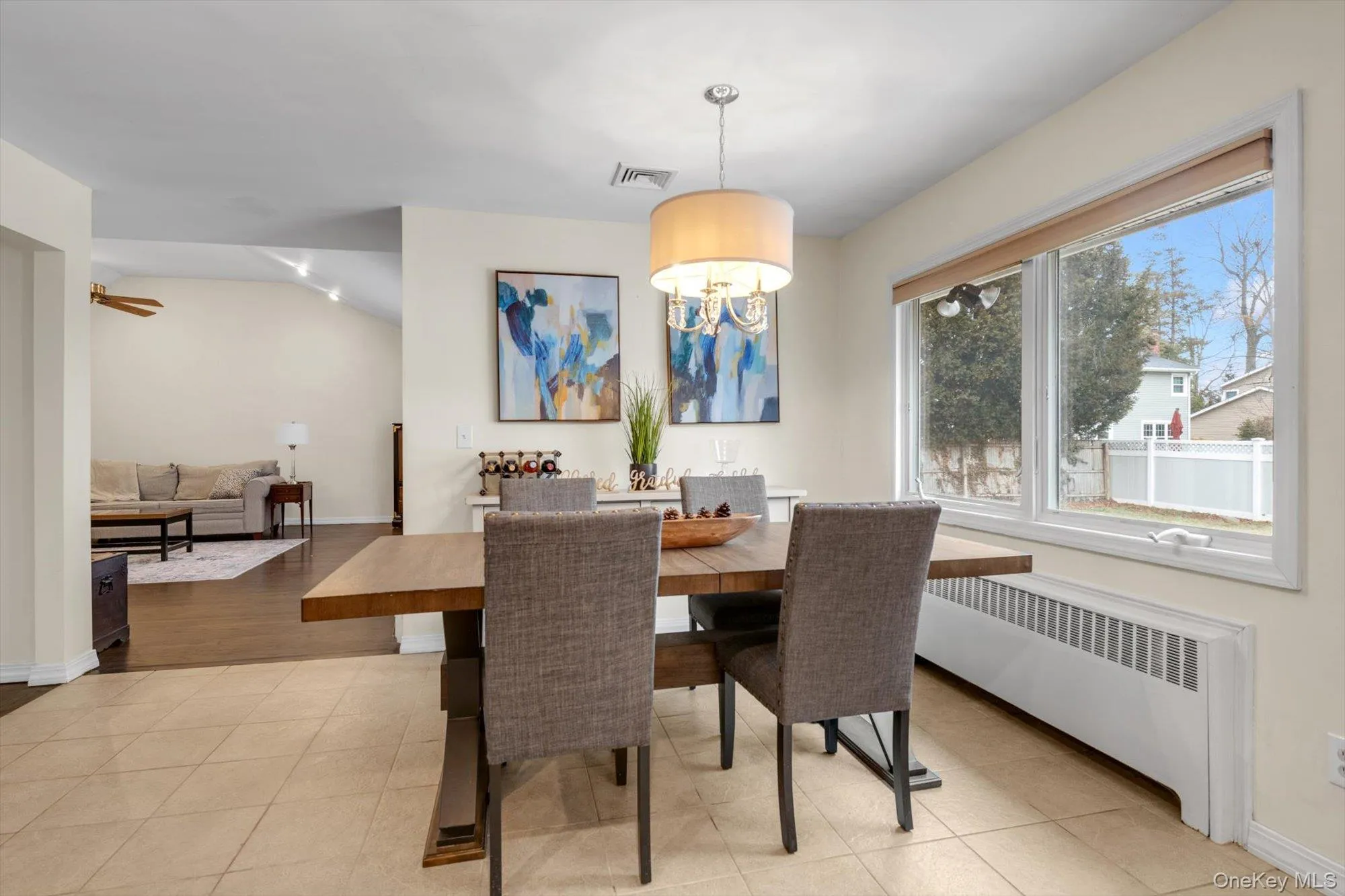 Dining area featuring tile flooring, a large window with natural light, and a drum pendant light fixture Dining area featuring tile flooring, a large window with natural light, and a drum pendant light fixture
