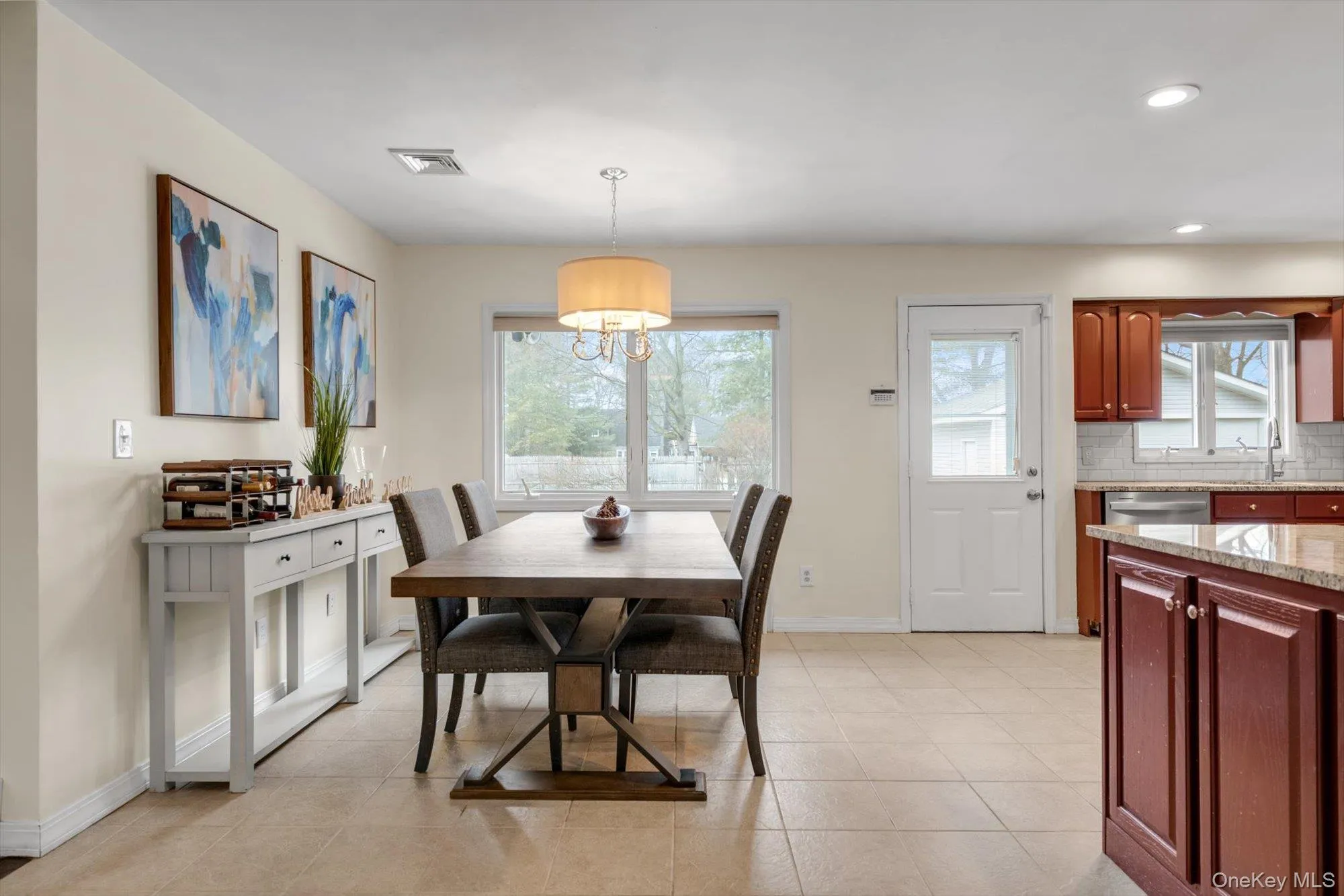 Open-concept dining area featuring neutral wall tones, a contemporary chandelier, and large windows Open-concept dining area featuring neutral wall tones, a contemporary chandelier, and large windows