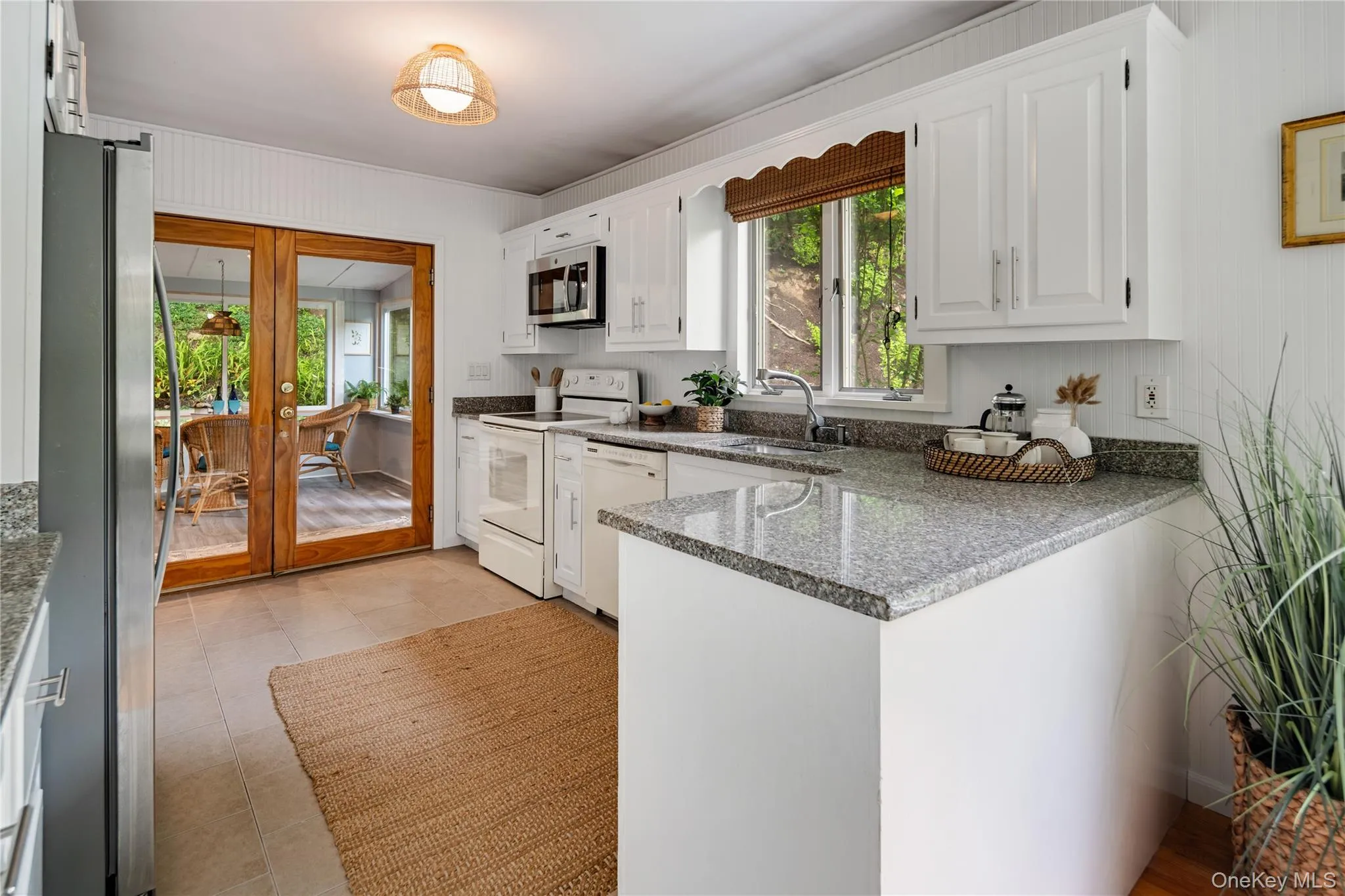 French doors open to the three-season room, and the ample granite countertop space is sure to delight any chef. French doors open to the three-season room, and the ample granite countertop space is sure to delight any chef.