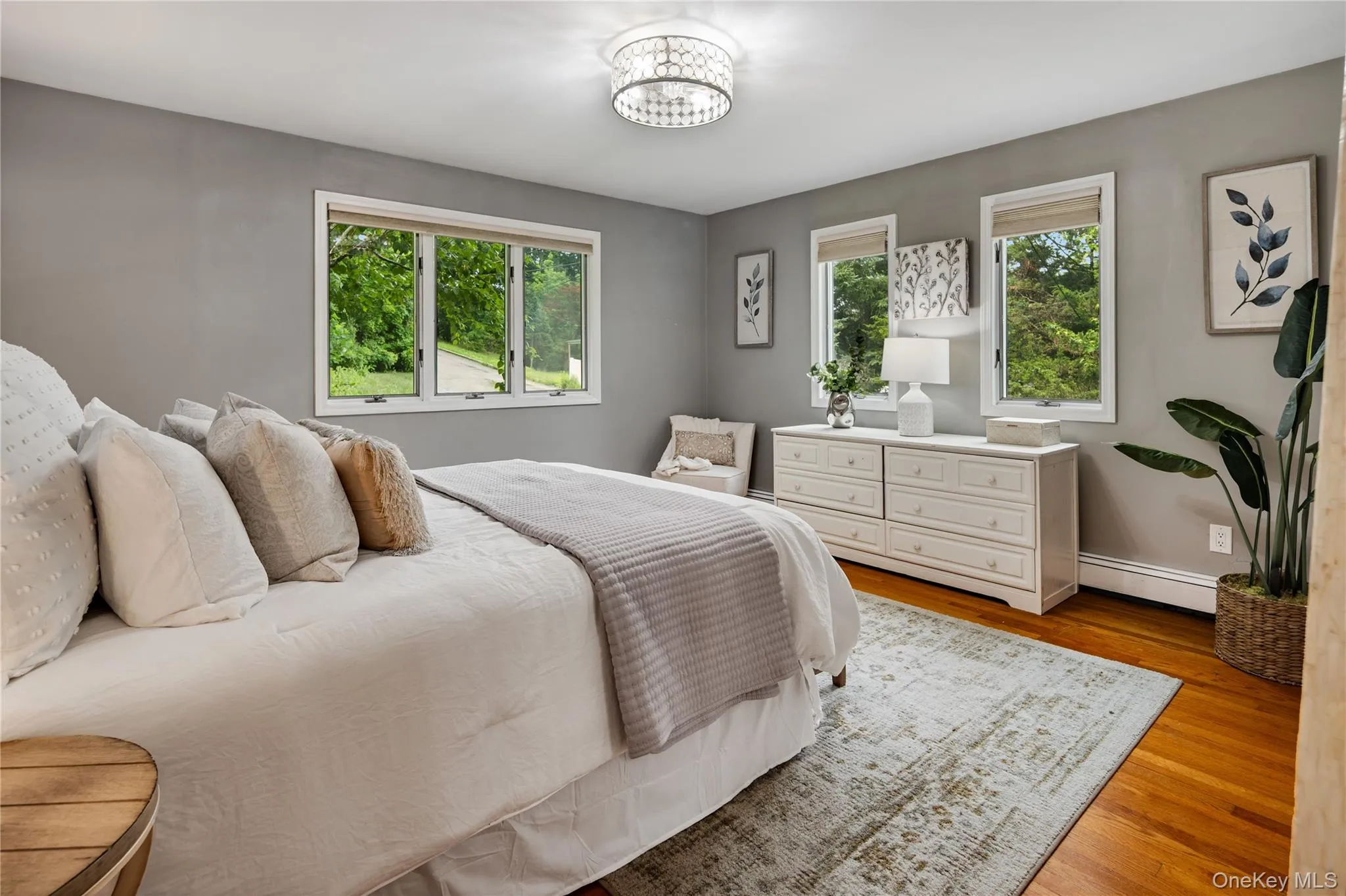 Spacious and serene primary bedroom with multiple windows filling the room with natural light and beautiful garden views. Spacious and serene primary bedroom with multiple windows filling the room with natural light and beautiful garden views.