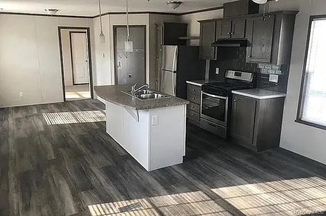 kitchen and living area featuring wood-finish flooring kitchen and living area featuring wood-finish flooring