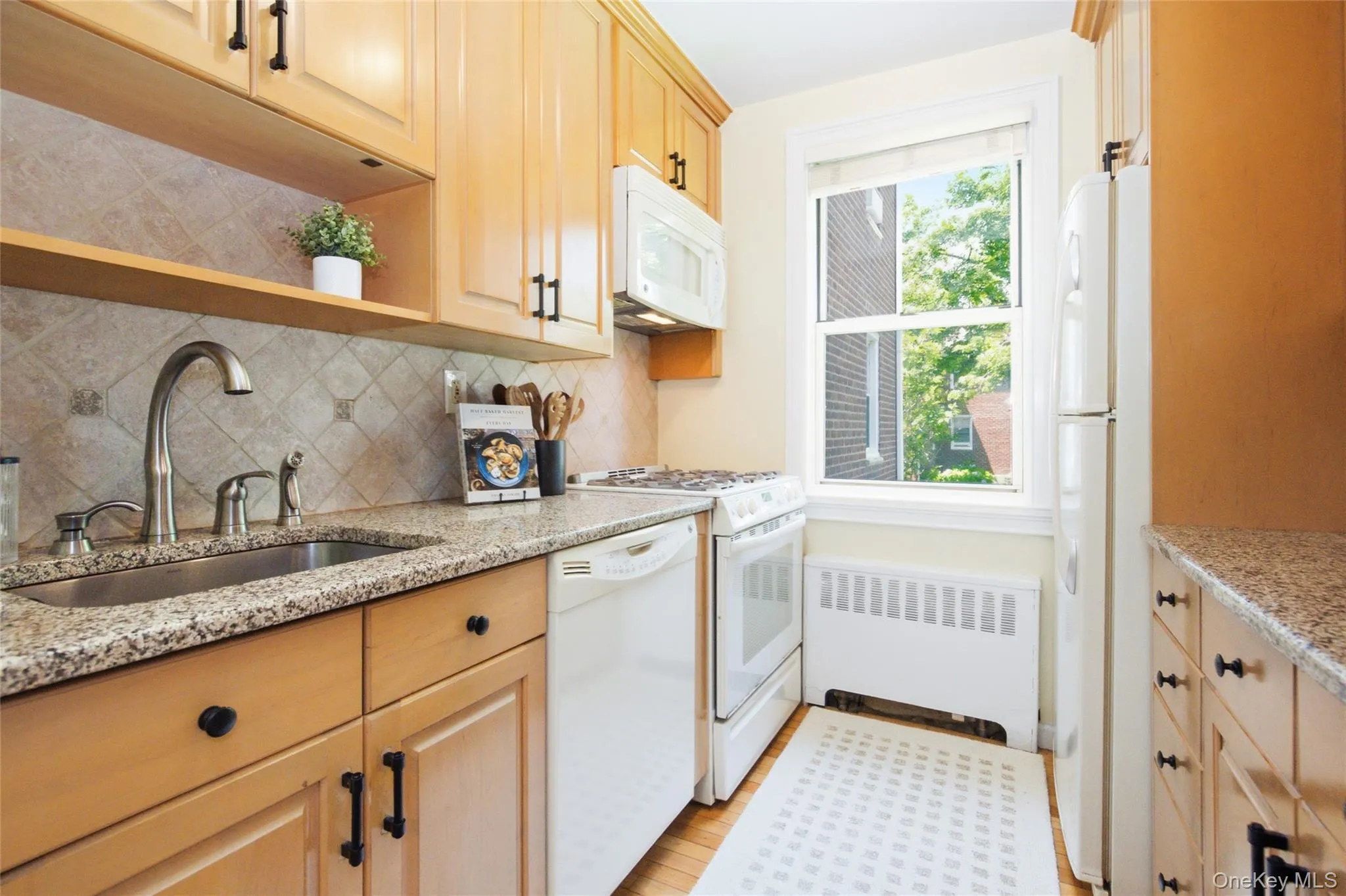 Alternate view of the kitchen showcasing ample counter space, classic finishes, and a functional layout ideal for everyday living. Alternate view of the kitchen showcasing ample counter space, classic finishes, and a functional layout ideal for everyday living.