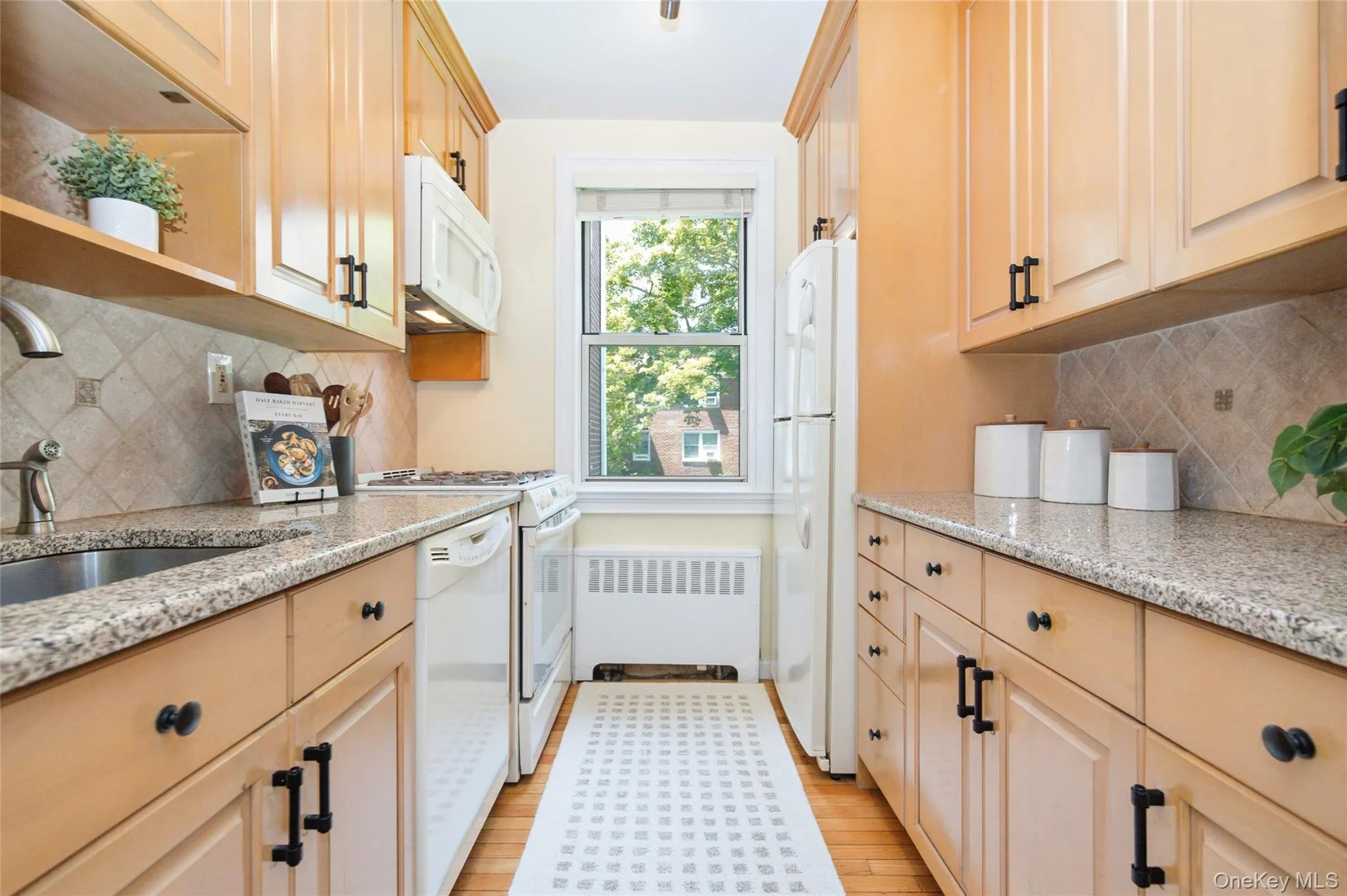 Bright kitchen featuring abundant cabinetry, granite countertops, and a charming window overlooking the yard. Bright kitchen featuring abundant cabinetry, granite countertops, and a charming window overlooking the yard.