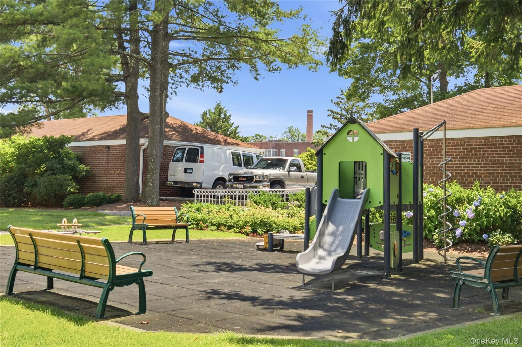 Landscaped recreation area featuring playground equipment and seating for residents to enjoy. Landscaped recreation area featuring playground equipment and seating for residents to enjoy.