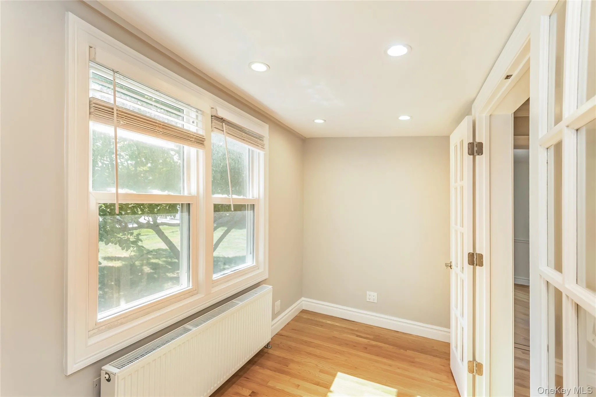 Spare room featuring radiator heating unit, light wood finished floors, and recessed lighting Spare room featuring radiator heating unit, light wood finished floors, and recessed lighting