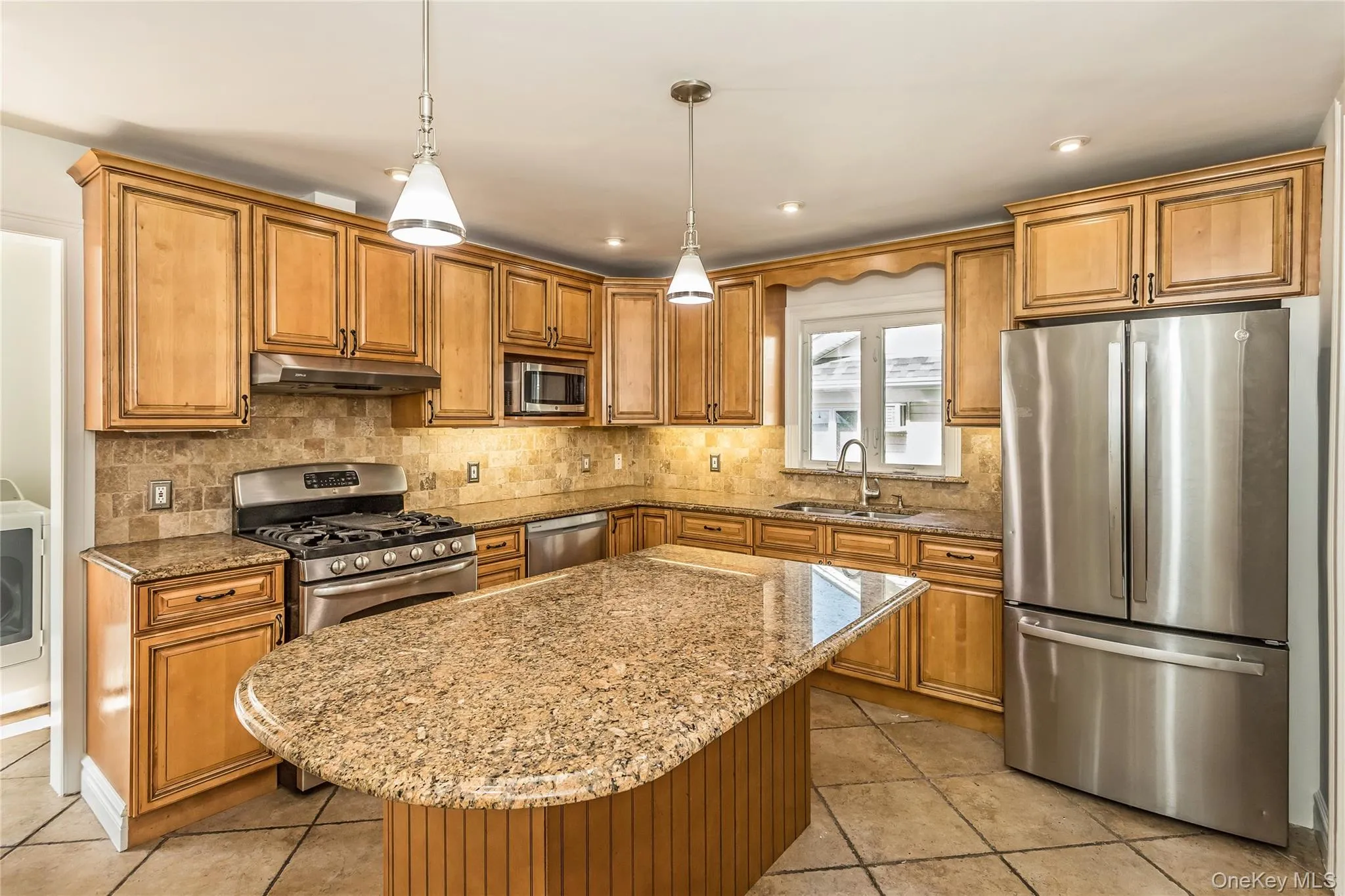 Kitchen featuring appliances with stainless steel finishes, brown cabinetry, light stone countertops, tasteful backsplash, and recessed lighting Kitchen featuring appliances with stainless steel finishes, brown cabinetry, light stone countertops, tasteful backsplash, and recessed lighting