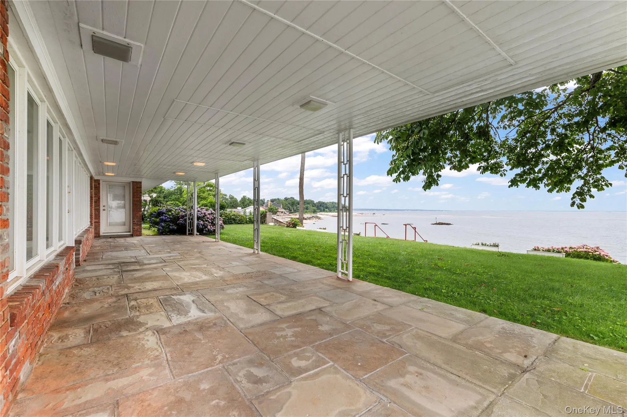 Rear stone covered patio overlooking the Sound. Rear stone covered patio overlooking the Sound.