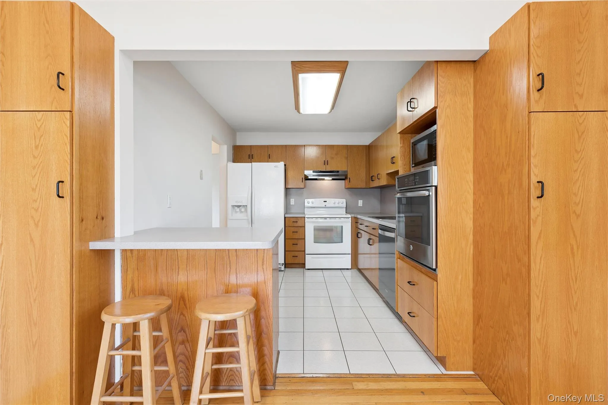 Kitchen with tile floor two ovens and wood cabinetry Kitchen with tile floor two ovens and wood cabinetry