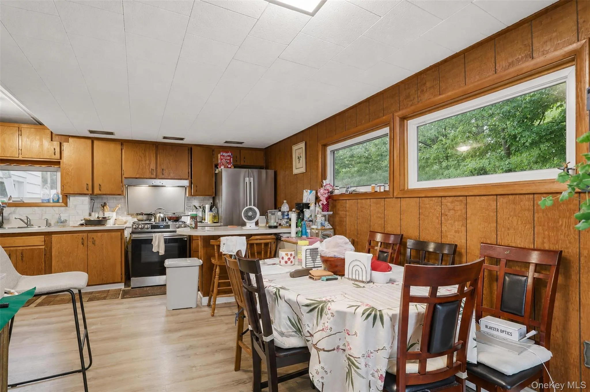 Kitchen featuring wood-finish cabinetry, stainless steel appliances, and light wood-finish flooring Kitchen featuring wood-finish cabinetry, stainless steel appliances, and light wood-finish flooring
