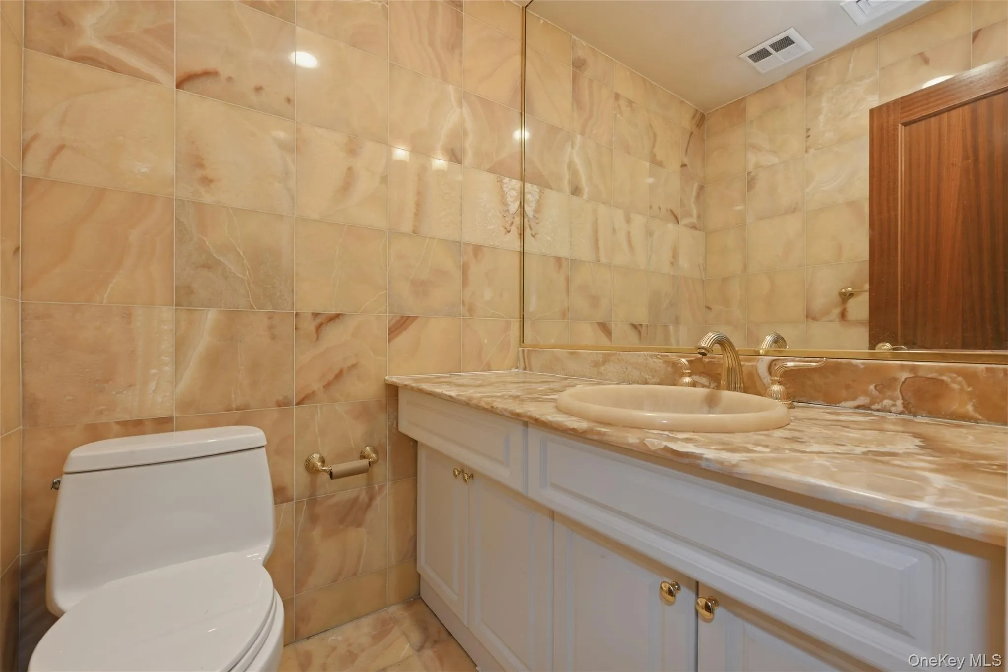 Bathroom featuring extensive stone tile walls and flooring Bathroom featuring extensive stone tile walls and flooring