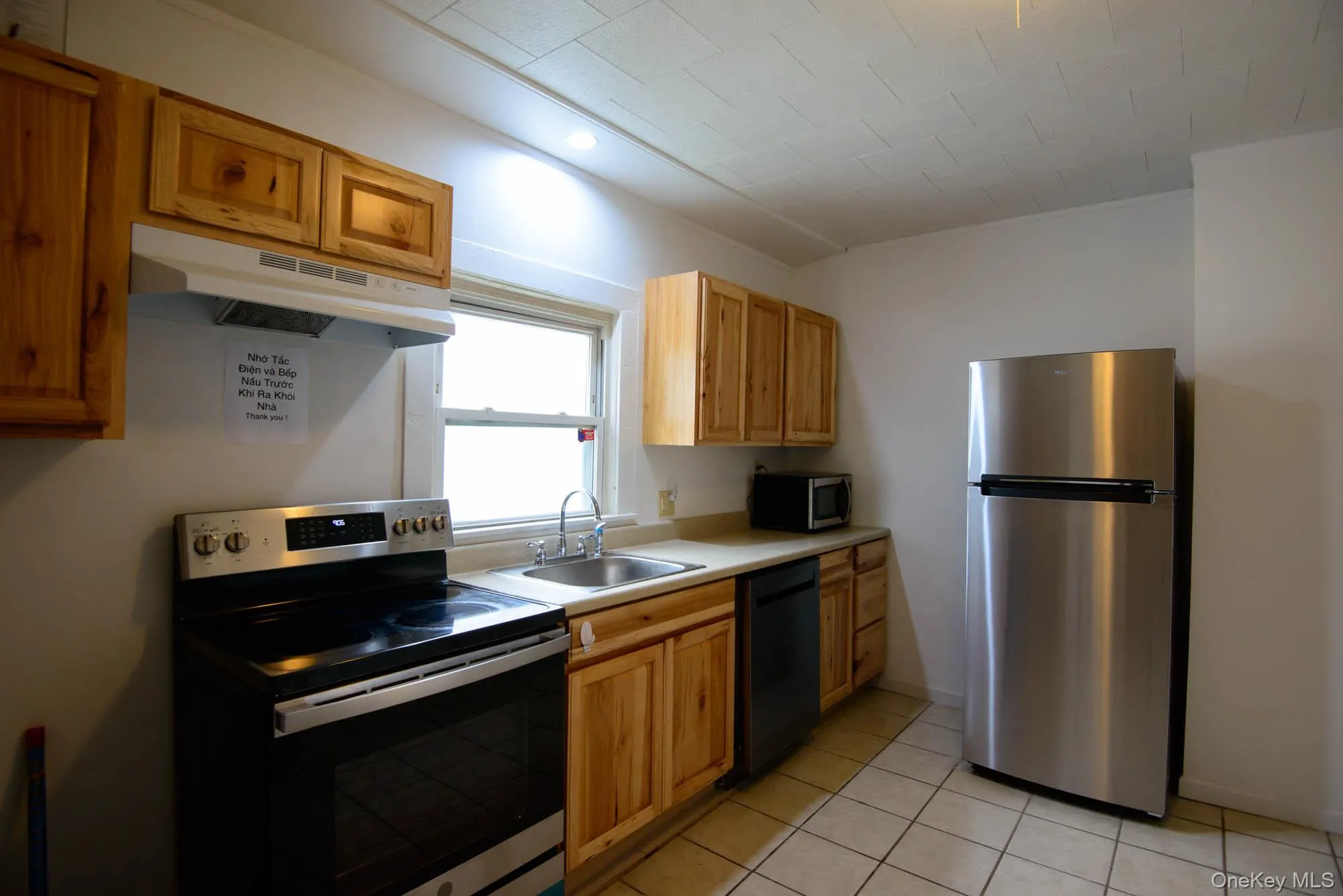 Kitchen featuring wood cabinetry, light-toned countertops, a stainless steel refrigerator, and a stainless steel range . Kitchen featuring wood cabinetry, light-toned countertops, a stainless steel refrigerator, and a stainless steel range .