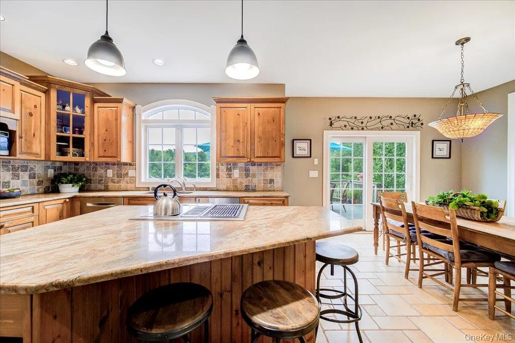 Massive granite kitchen island with downdraft cook top and high end wood cabinets and updated appliances. Massive granite kitchen island with downdraft cook top and high end wood cabinets and updated appliances.
