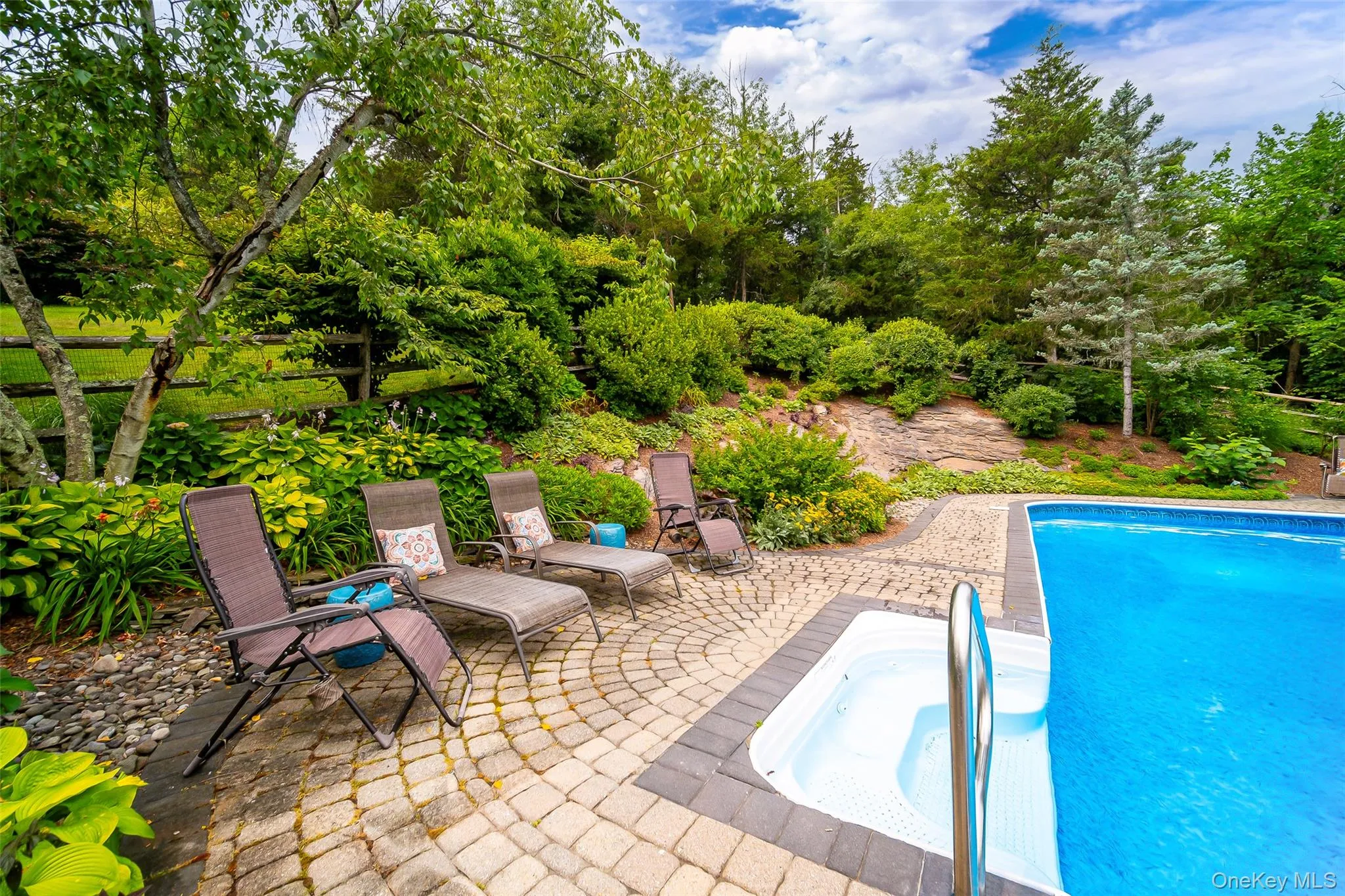 Lovely landscaping and carefully planned seating areas surround this custom pool area. Lovely landscaping and carefully planned seating areas surround this custom pool area.