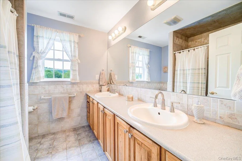 Nicely appointed full hall bath with double vanity. Nicely appointed full hall bath with double vanity.
