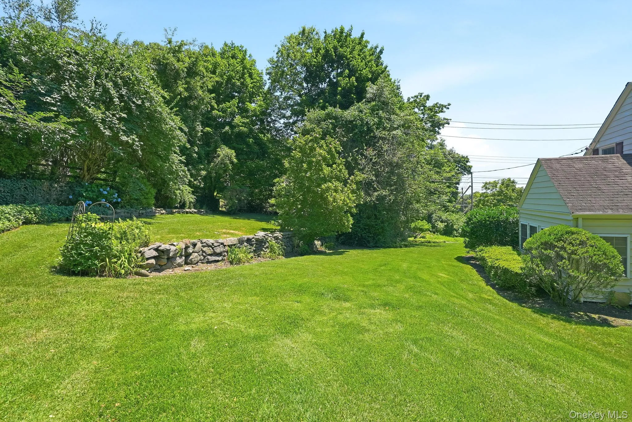View of backyard showing stone wall and private, upper grassy area View of backyard showing stone wall and private, upper grassy area