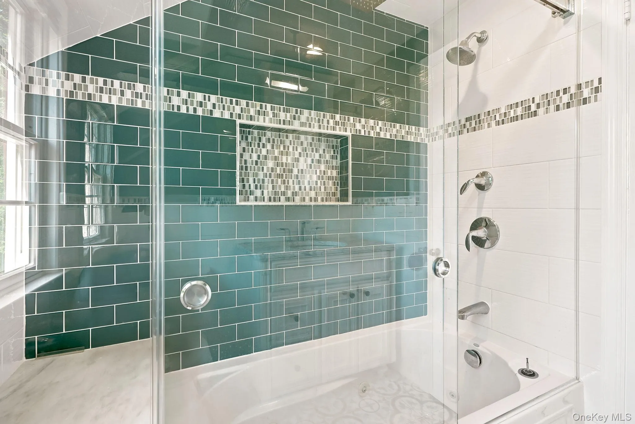 Detail of Tub/shower combination in second floor hall bath featuring a jetted tub and lovely tile work Detail of Tub/shower combination in second floor hall bath featuring a jetted tub and lovely tile work