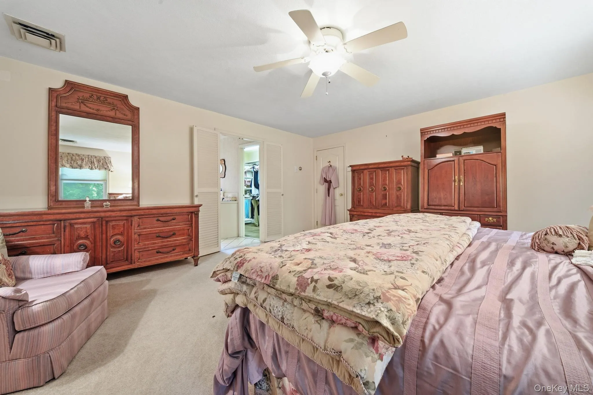 Bedroom featuring neutral carpet flooring and a ceiling fan Bedroom featuring neutral carpet flooring and a ceiling fan