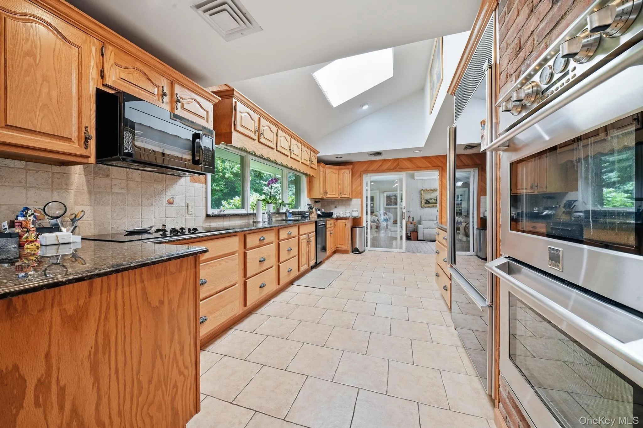 Kitchen featuring granite countertops, light wood cabinetry, and stainless steel appliances Kitchen featuring granite countertops, light wood cabinetry, and stainless steel appliances