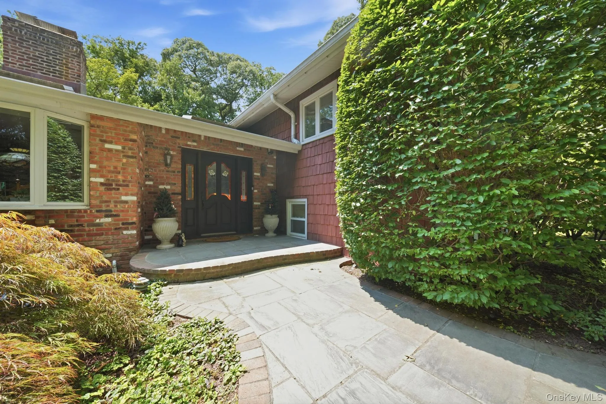 Brick and shingle exterior with a prominent chimney Brick and shingle exterior with a prominent chimney