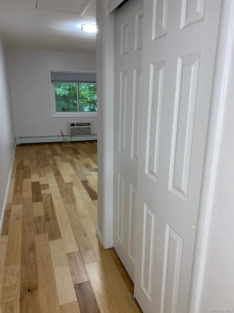 Entrance to spacious primary bedroom with wood floors and 2 double closets Entrance to spacious primary bedroom with wood floors and 2 double closets