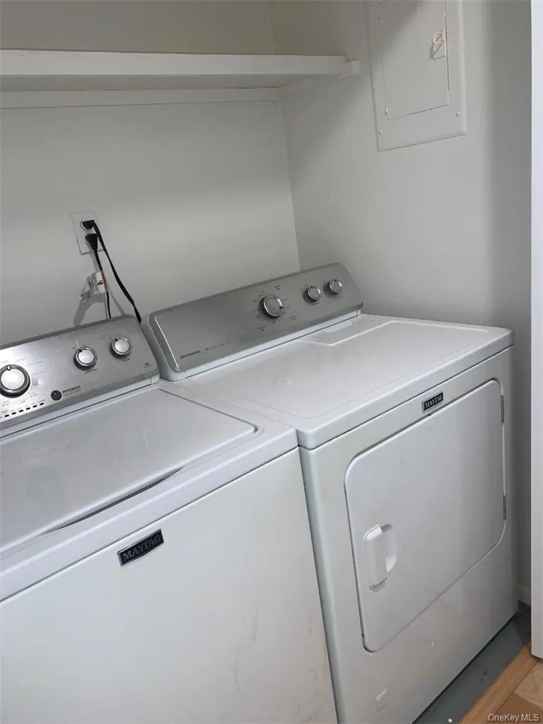 Full size washer/dryer within apt with a storage shelf above Full size washer/dryer within apt with a storage shelf above