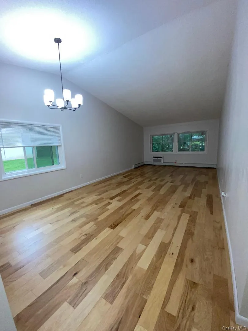 Huge living room with cathedral ceilings, a dining area and wood floors throughout Huge living room with cathedral ceilings, a dining area and wood floors throughout