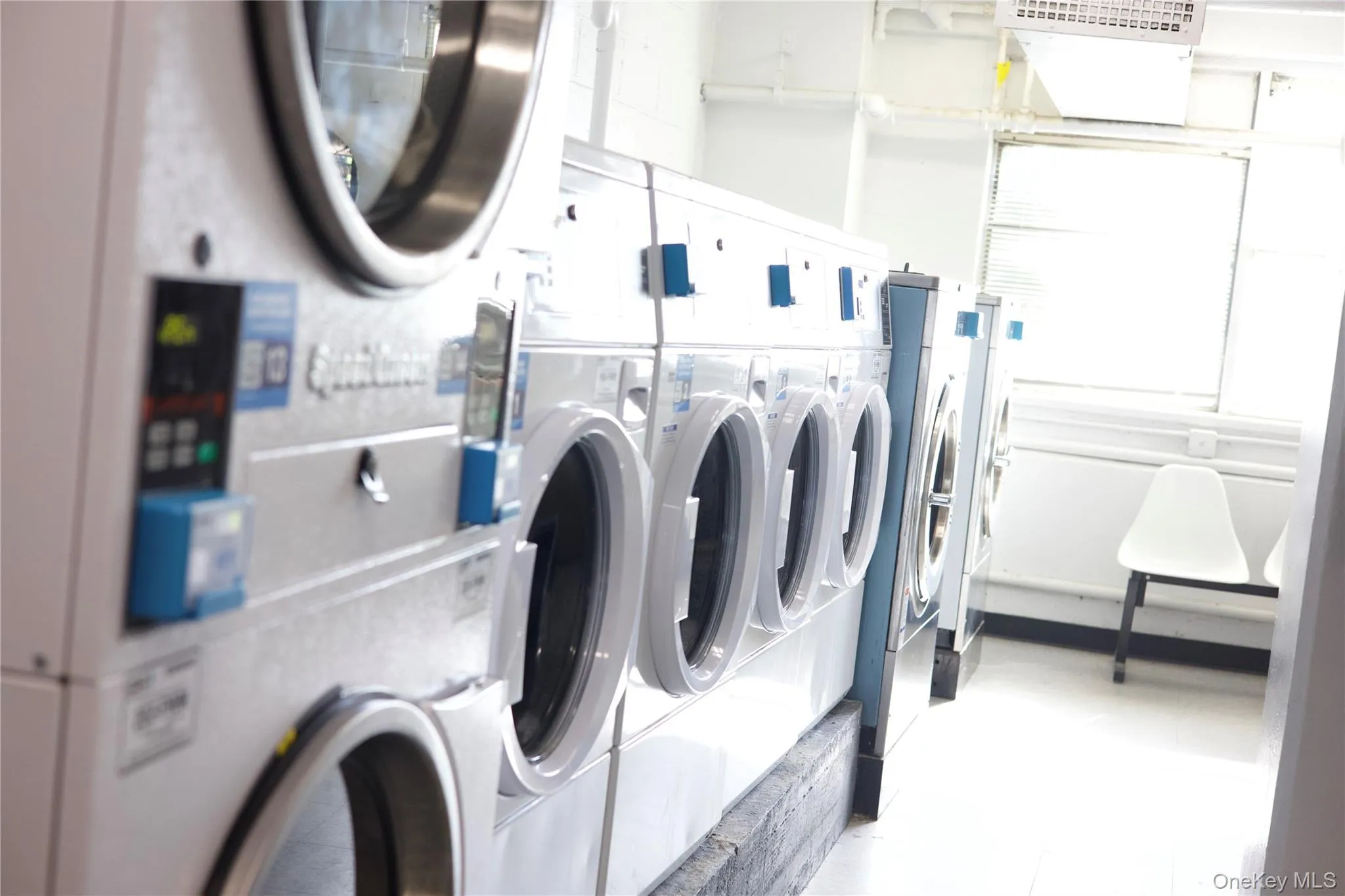 Building laundry room featuring washing machine and clothes dryer Building laundry room featuring washing machine and clothes dryer