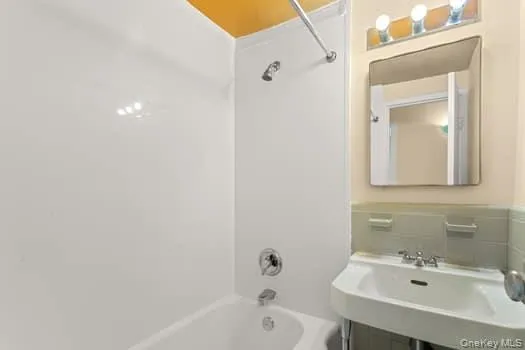 Full bath featuring shower / bathtub combination and a sink Full bath featuring shower / bathtub combination and a sink