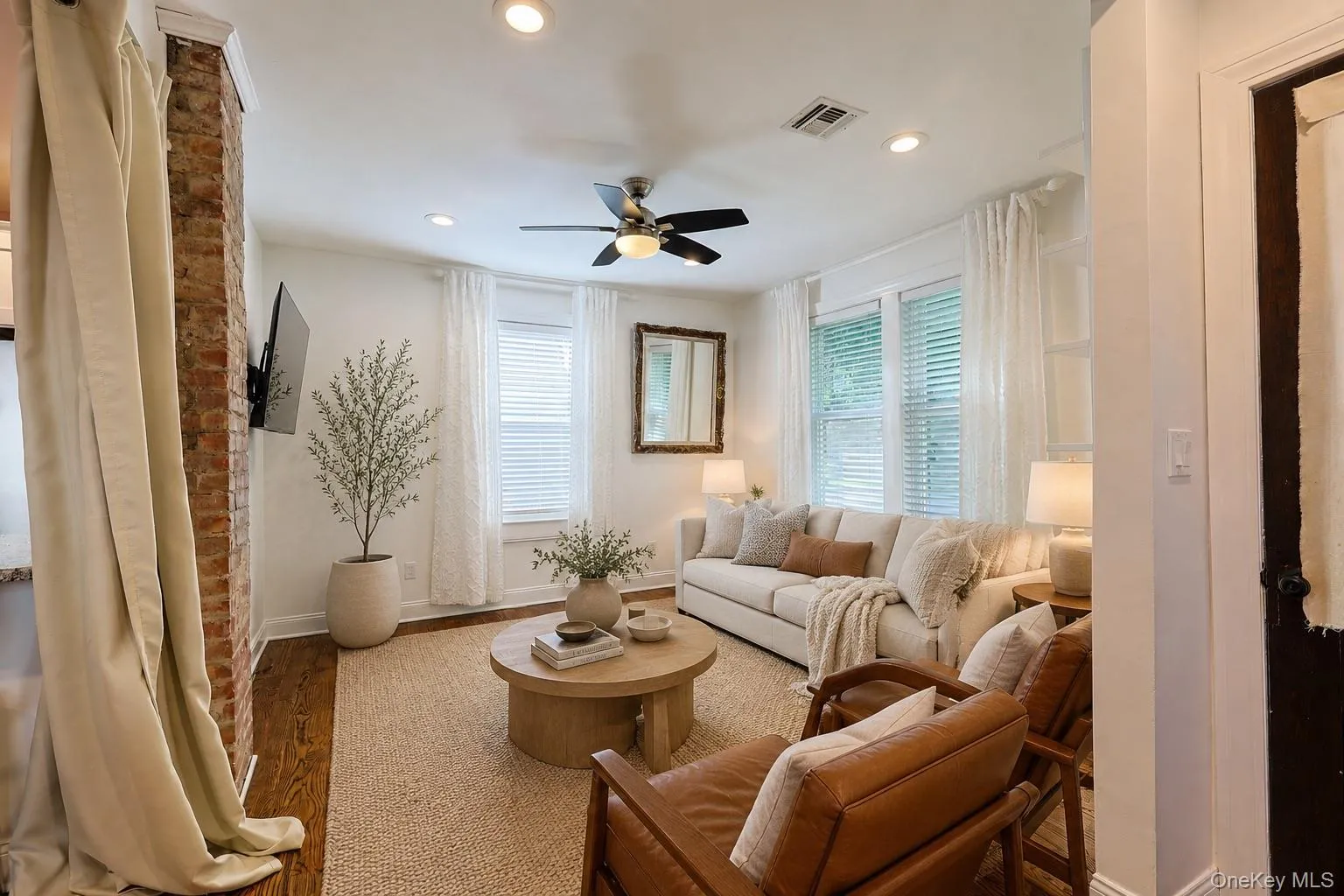 Virtually-staged living area featuring an exposed brick architectural element, recessed lighting, and a ceiling fan Virtually-staged living area featuring an exposed brick architectural element, recessed lighting, and a ceiling fan