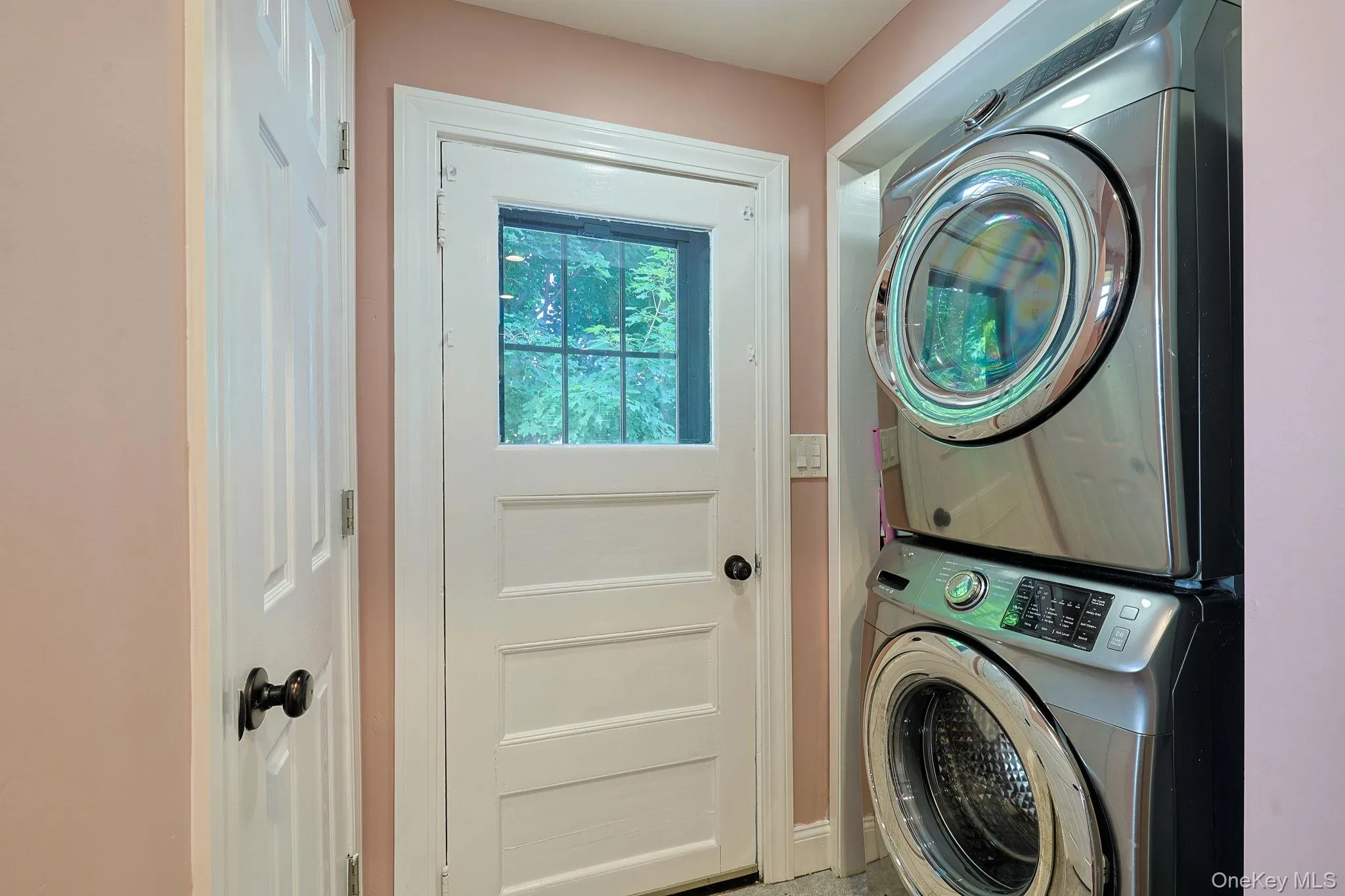 Dedicated laundry area featuring a stacked washer and dryer unit Dedicated laundry area featuring a stacked washer and dryer unit
