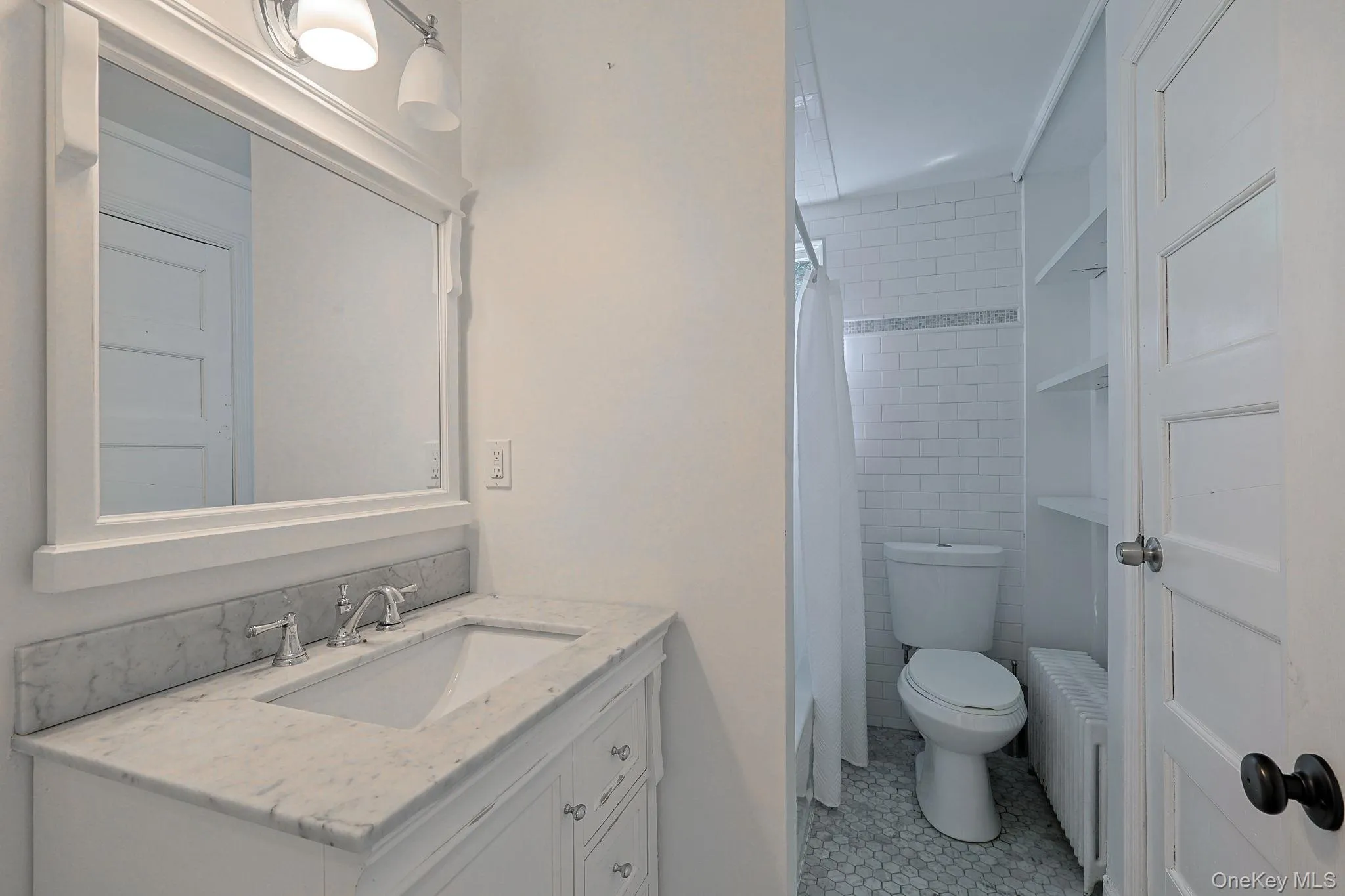 Bathroom vanity with a white framed mirror, white cabinetry, integrated sink, and stone-finish countertop Bathroom vanity with a white framed mirror, white cabinetry, integrated sink, and stone-finish countertop