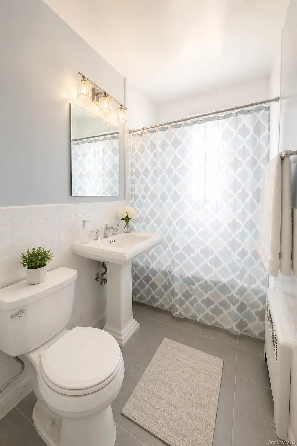 Full bathroom featuring a white pedestal sink, toilet, and bathtub with shower Full bathroom featuring a white pedestal sink, toilet, and bathtub with shower