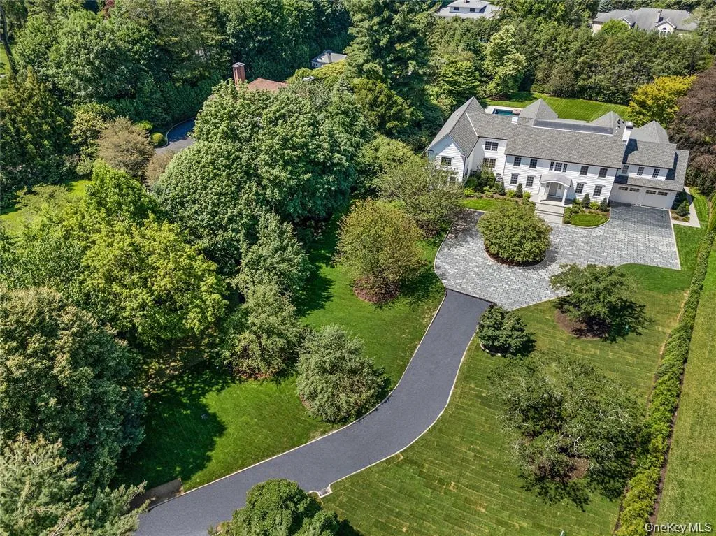A sweeping aerial view highlights the estate's impressive approach, expansive circular driveway, and picturesque setting surrounded by mature specimen trees. A sweeping aerial view highlights the estate's impressive approach, expansive circular driveway, and picturesque setting surrounded by mature specimen trees.