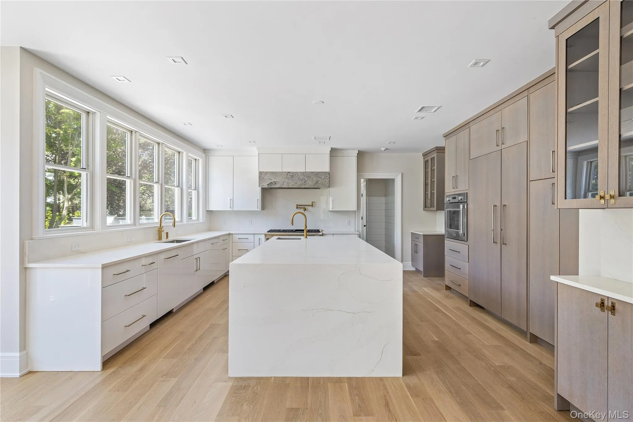 The spectacular chef's kitchen is appointed with custom cabinetry, premium Thermador appliances, an oversized waterfall quartzite island, and abundant prep space. The spectacular chef's kitchen is appointed with custom cabinetry, premium Thermador appliances, an oversized waterfall quartzite island, and abundant prep space.
