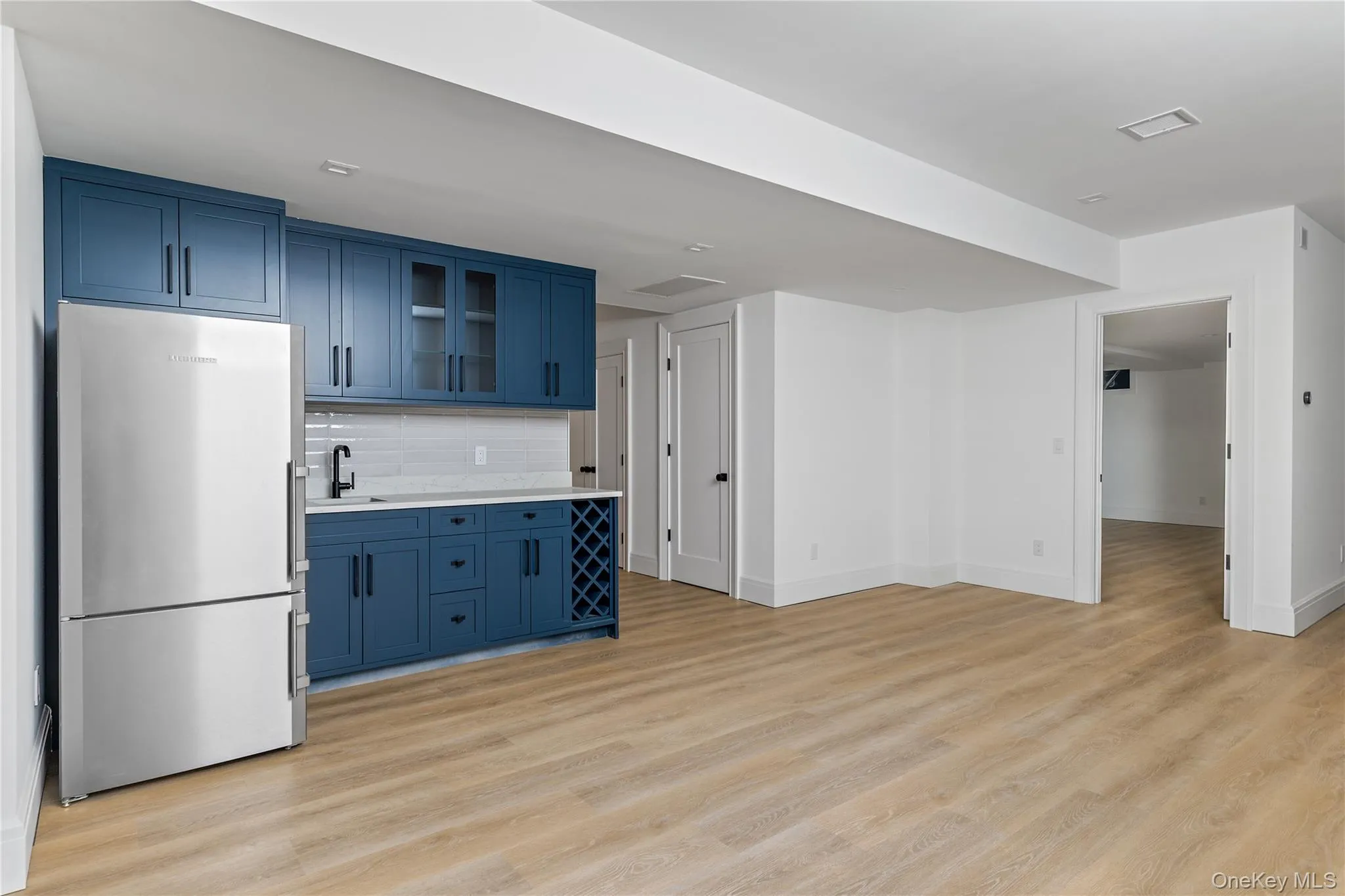 The finished lower level includes a spacious recreation room with a beautifully appointed kitchenette featuring custom cabinetry, a full-size refrigerator, and sink—perfect for entertaining or extended guest stays. The finished lower level includes a spacious recreation room with a beautifully appointed kitchenette featuring custom cabinetry, a full-size refrigerator, and sink—perfect for entertaining or extended guest stays.