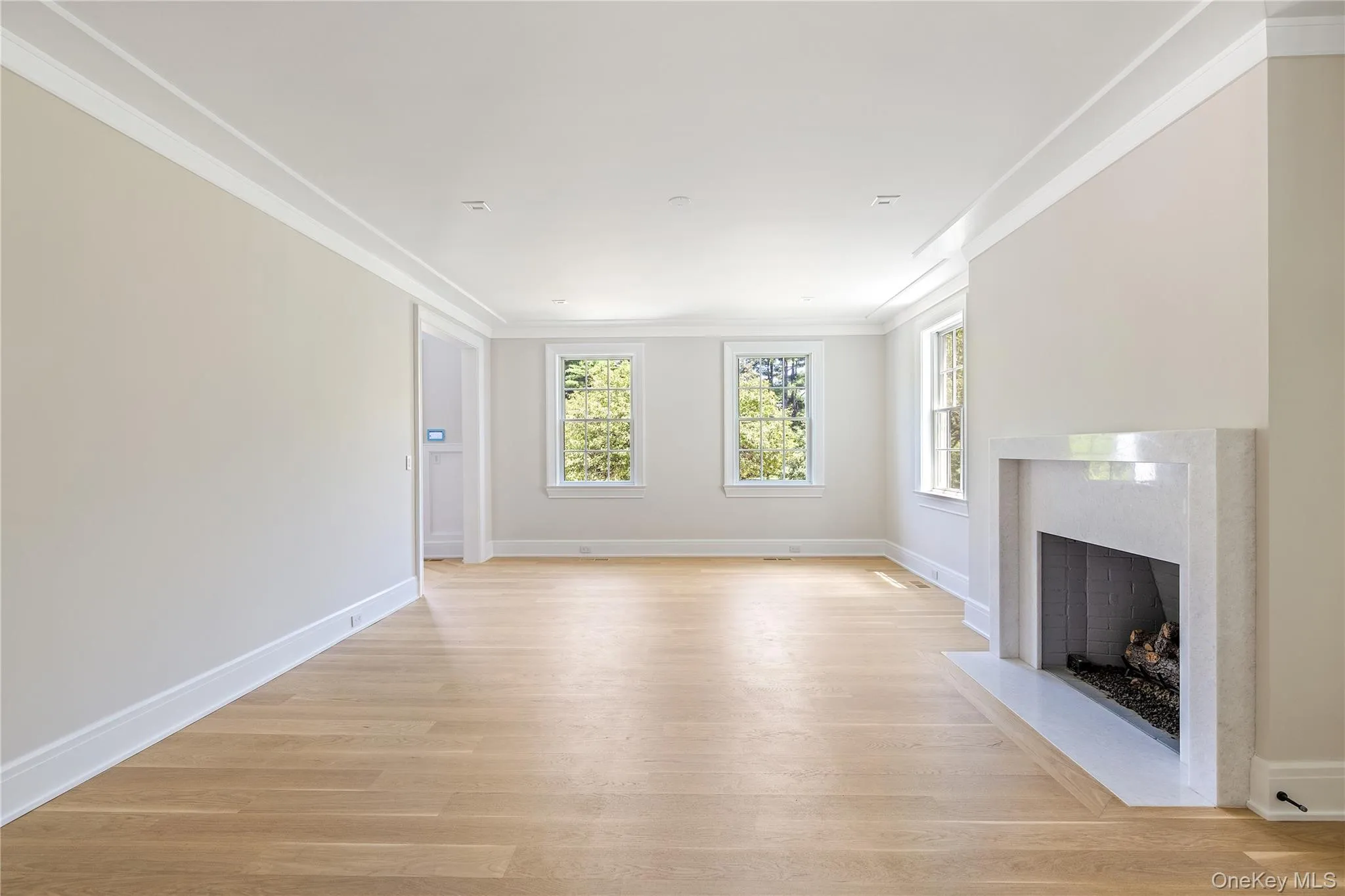 The gracious formal living room offers an inviting setting for entertaining, centered around a sleek marble fireplace and oversized windows that fill the space with natural light. The gracious formal living room offers an inviting setting for entertaining, centered around a sleek marble fireplace and oversized windows that fill the space with natural light.