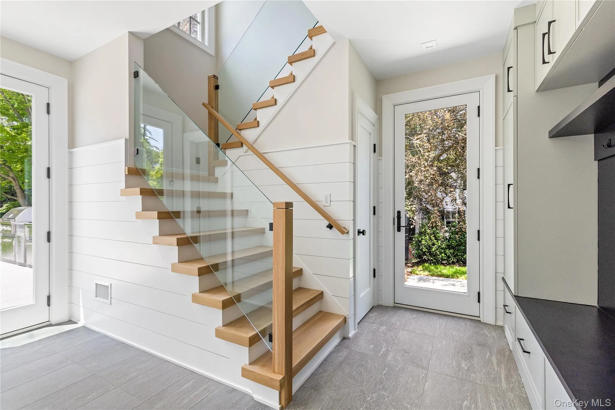 A thoughtfully designed secondary entrance/mudroom features a custom staircase, side entry, direct access to the backyard and attached garage, plus a convenient full bath ideal after a swim or time outdoors. A thoughtfully designed secondary entrance/mudroom features a custom staircase, side entry, direct access to the backyard and attached garage, plus a convenient full bath ideal after a swim or time outdoors.